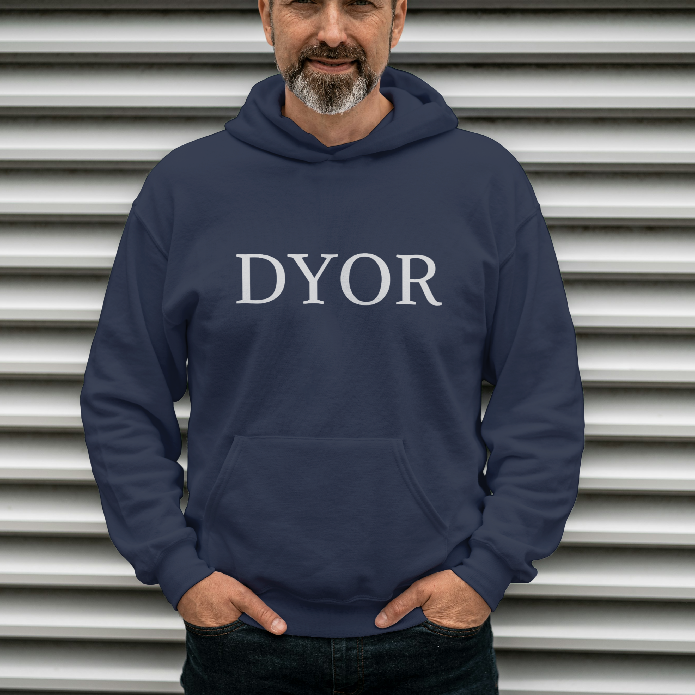 Man wearing a navy hoodie with 'DYOR' text against a metallic background