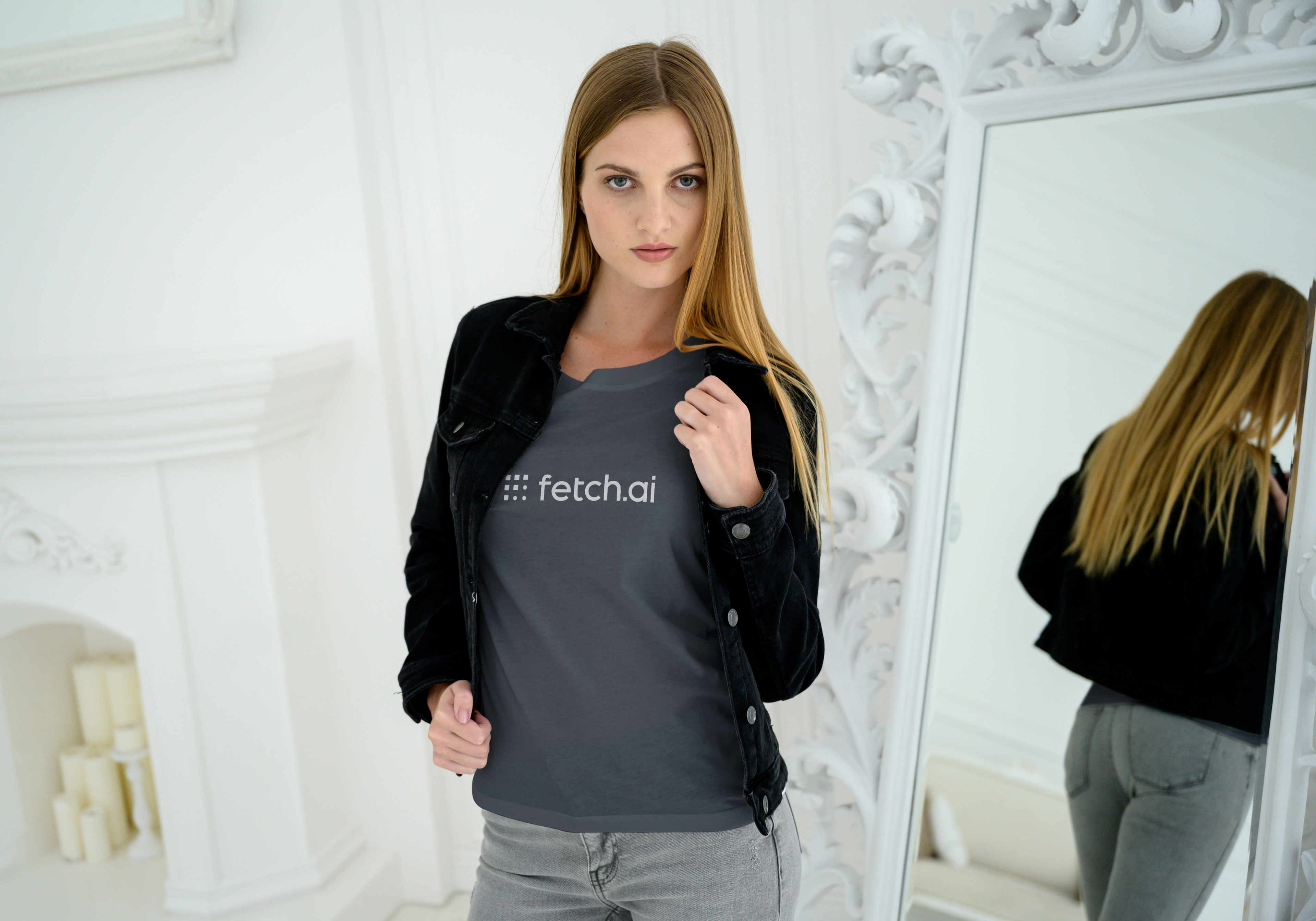 Woman wearing a dark gray t-shirt with 'fetch.ai' logo in a white room.