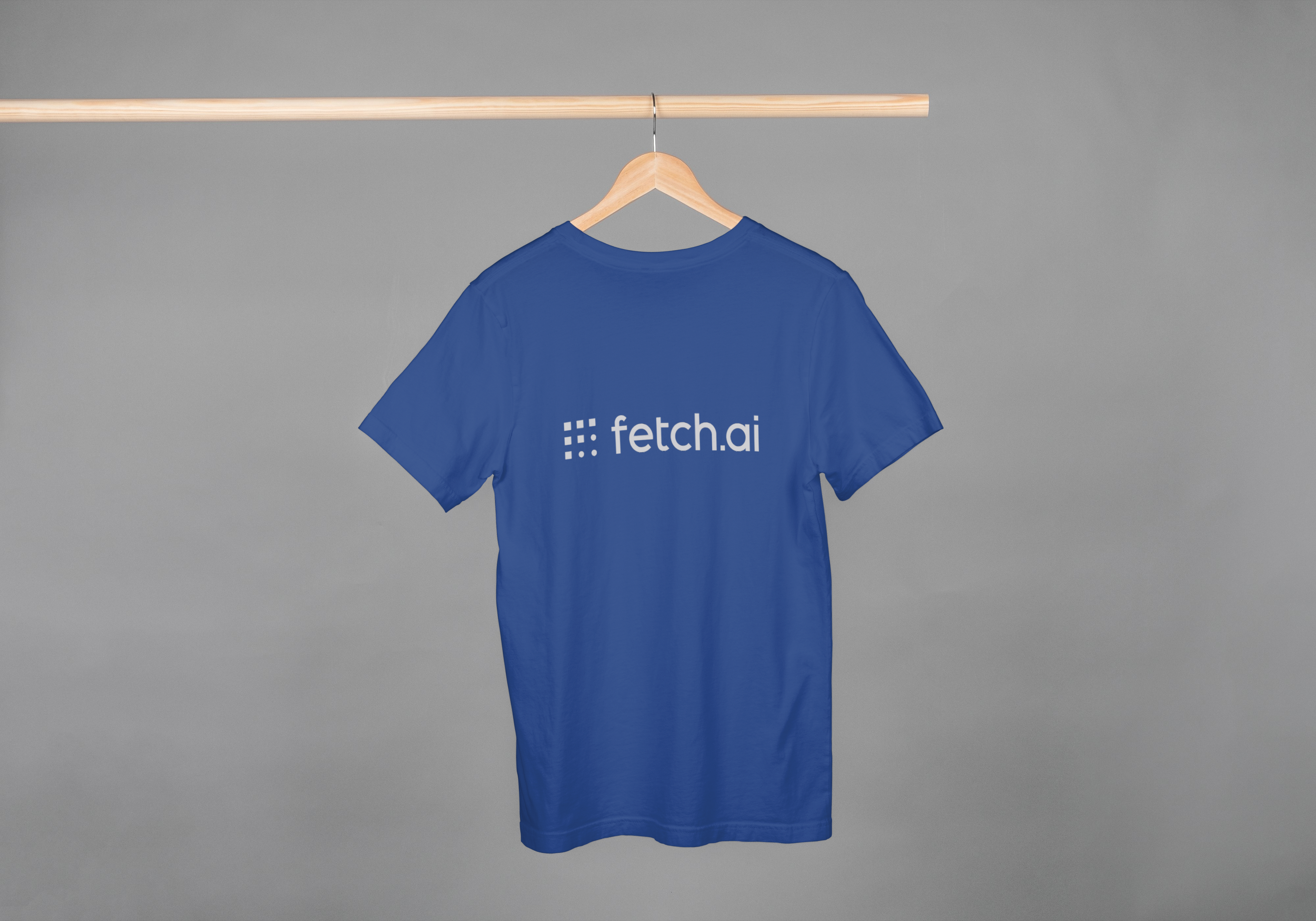 Blue t-shirt with 'fetch.ai' logo on a hanger against a gray background
