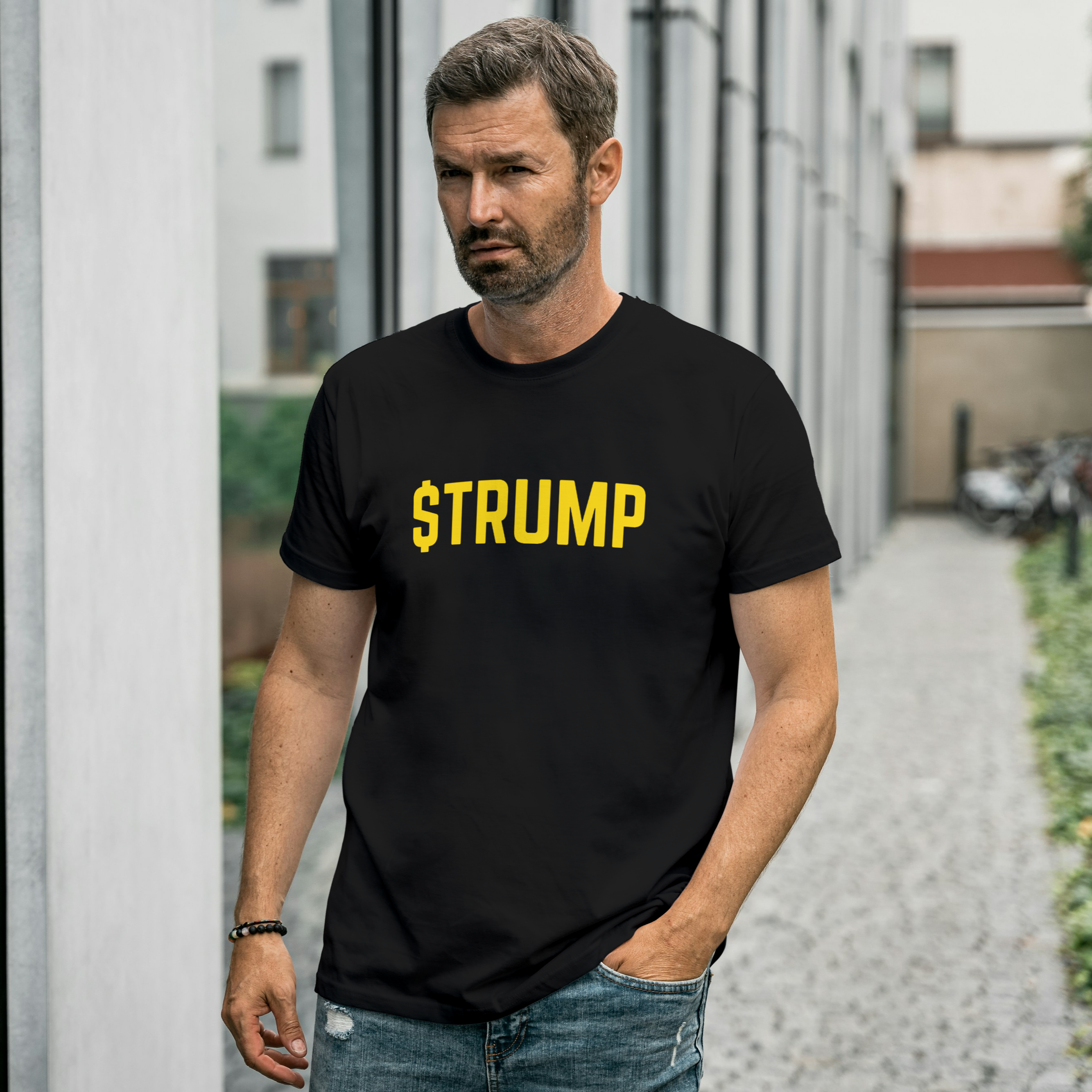 Man wearing a black t-shirt with 'STRUMP' printed in yellow, standing outdoors.
