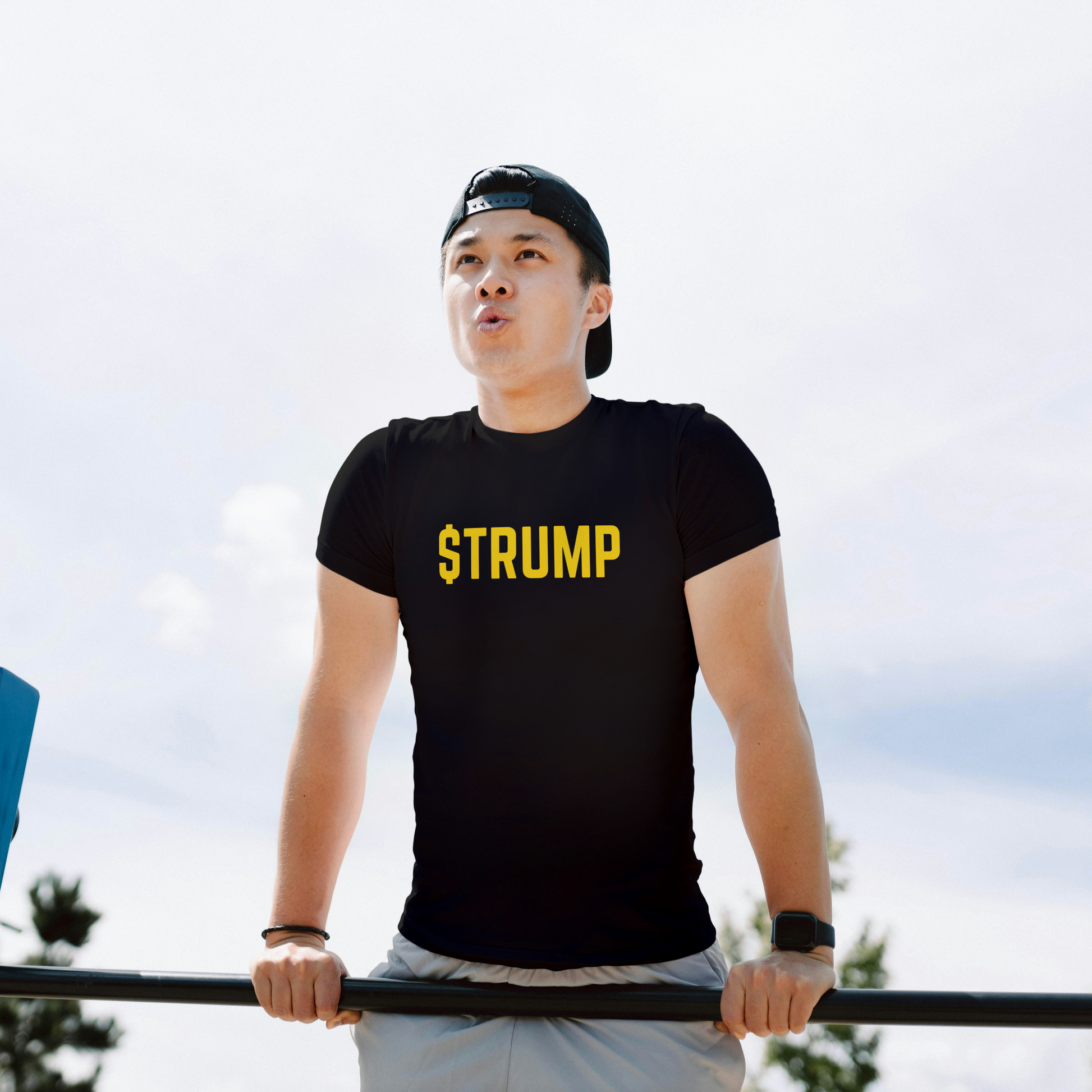 Person wearing a black t-shirt with 'STRUMP' on it, standing outdoors.