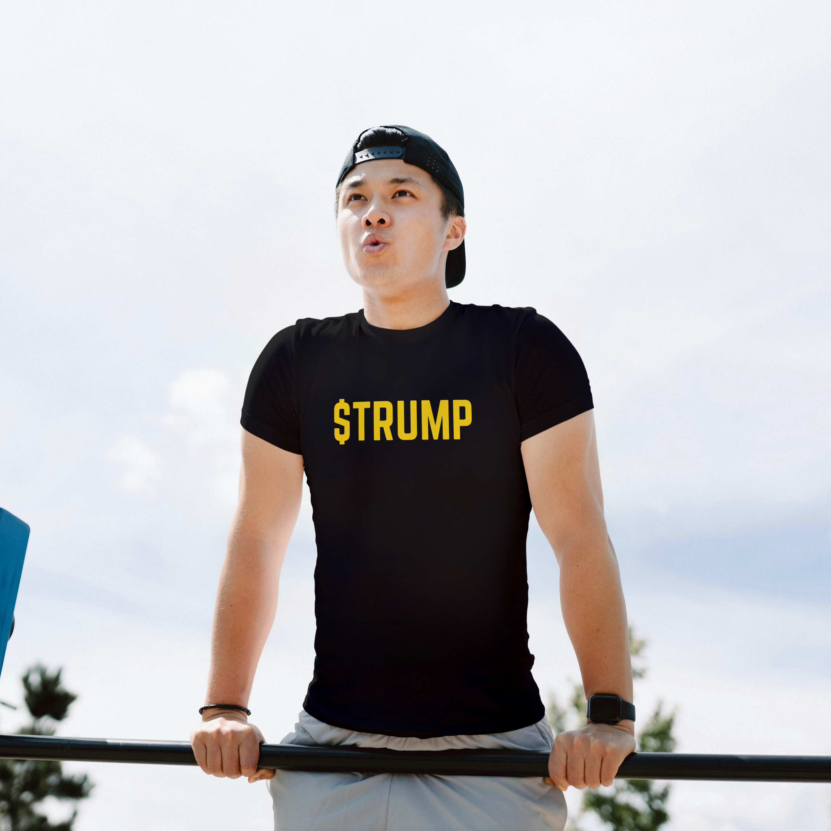 Person wearing a black t-shirt with 'STRUMP' on it, standing outdoors.