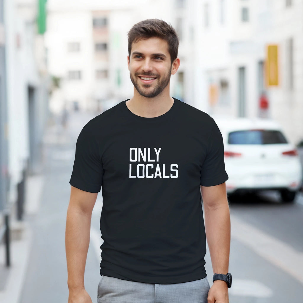 Man wearing a black t-shirt with 'ONLY LOCALS' text on a city street.