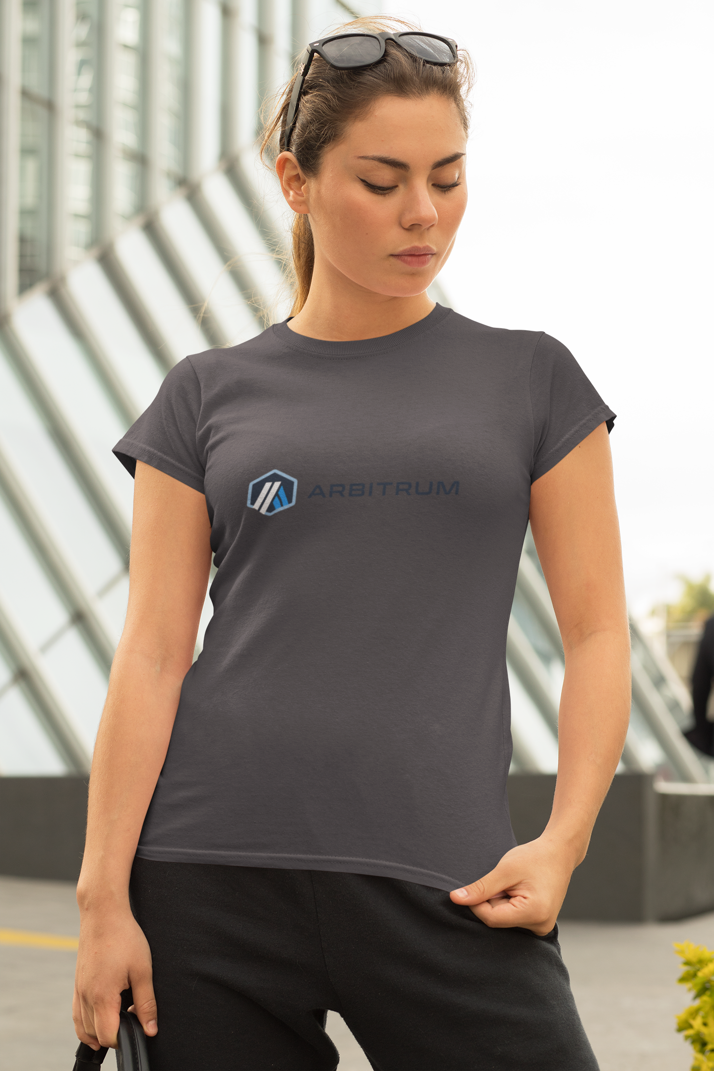 Woman wearing a gray t-shirt with a logo in an urban setting