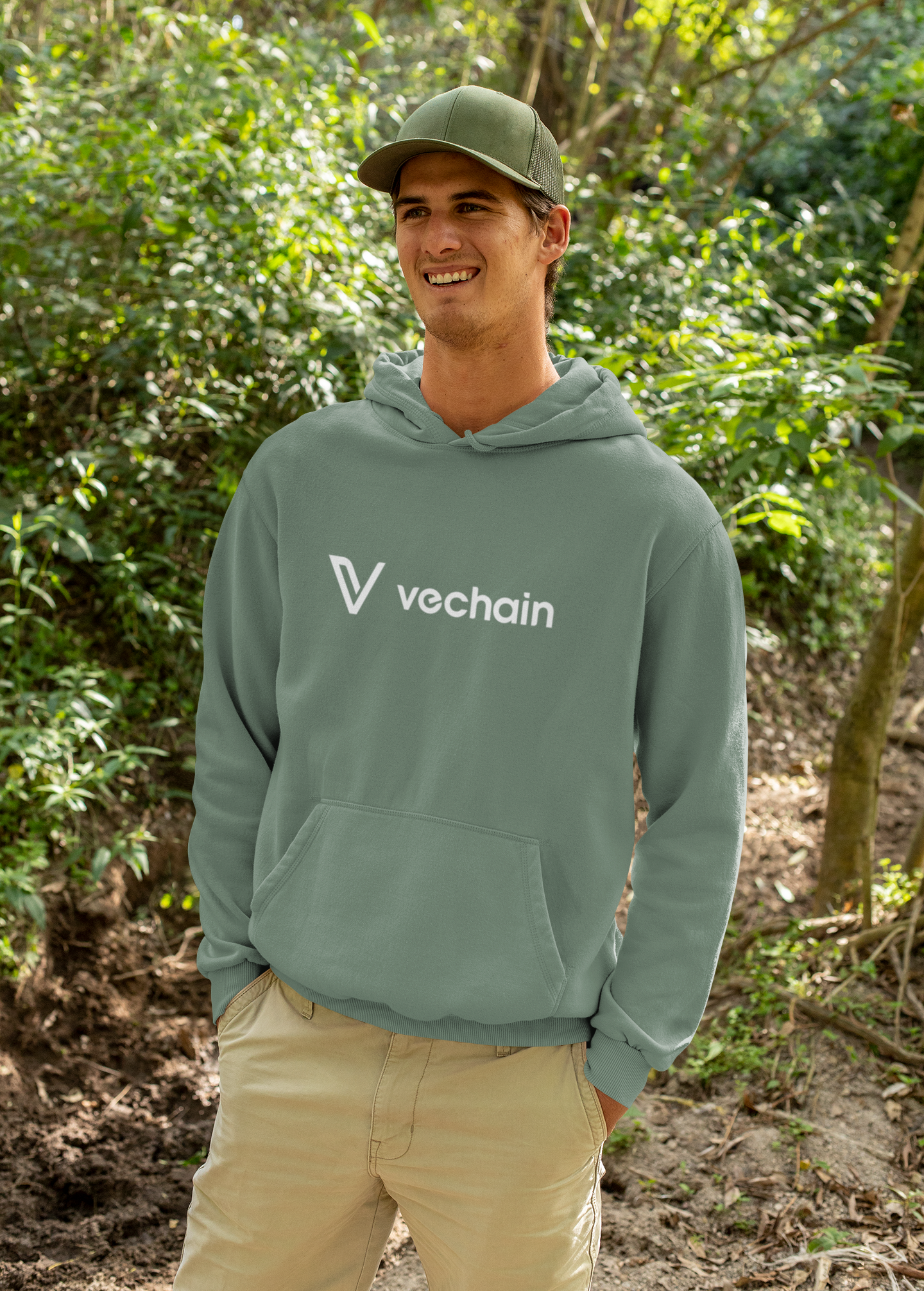 Person wearing a green Vechain hoodie standing in a forest