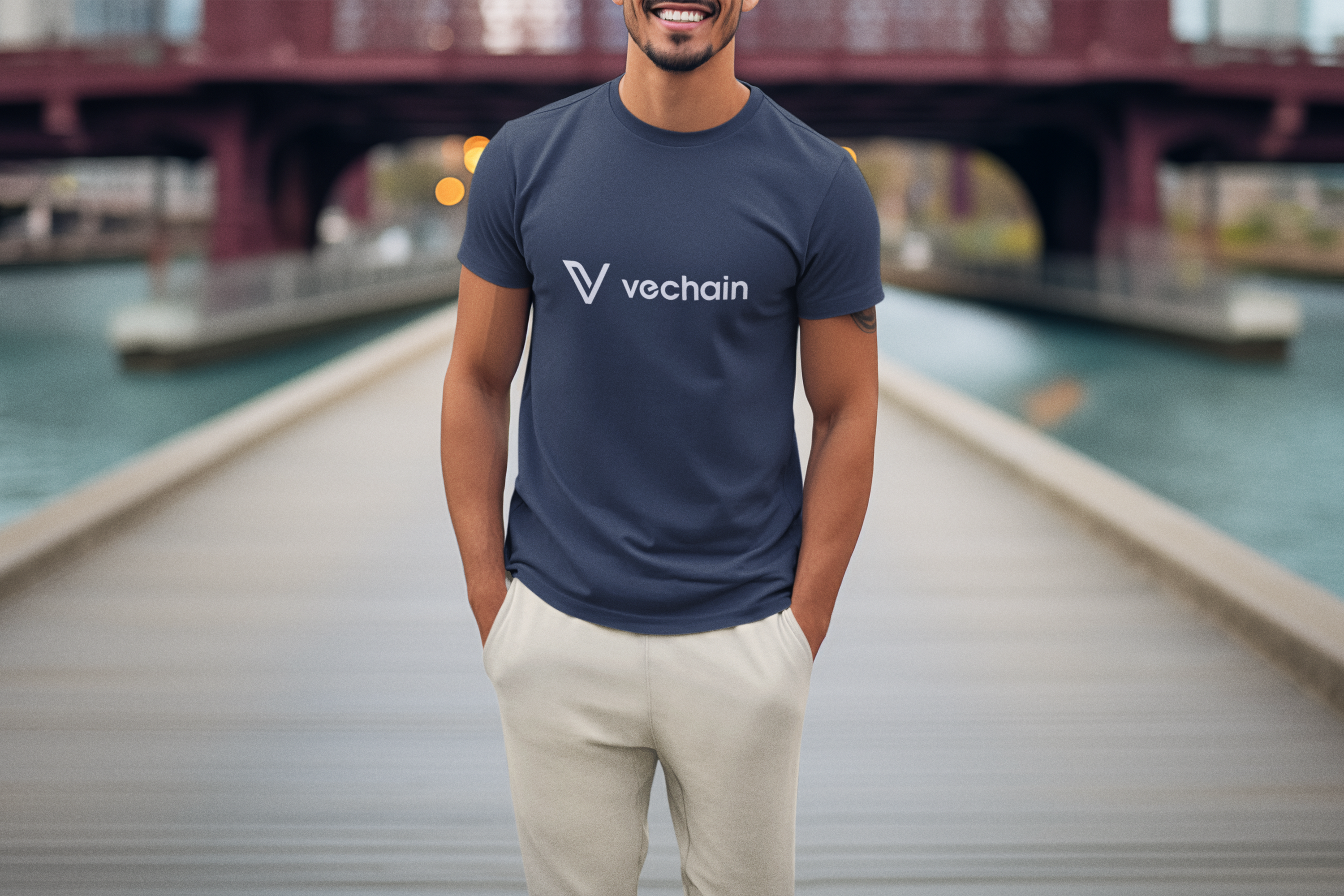 Man wearing a Vechain t-shirt standing on a dock with a blurred background