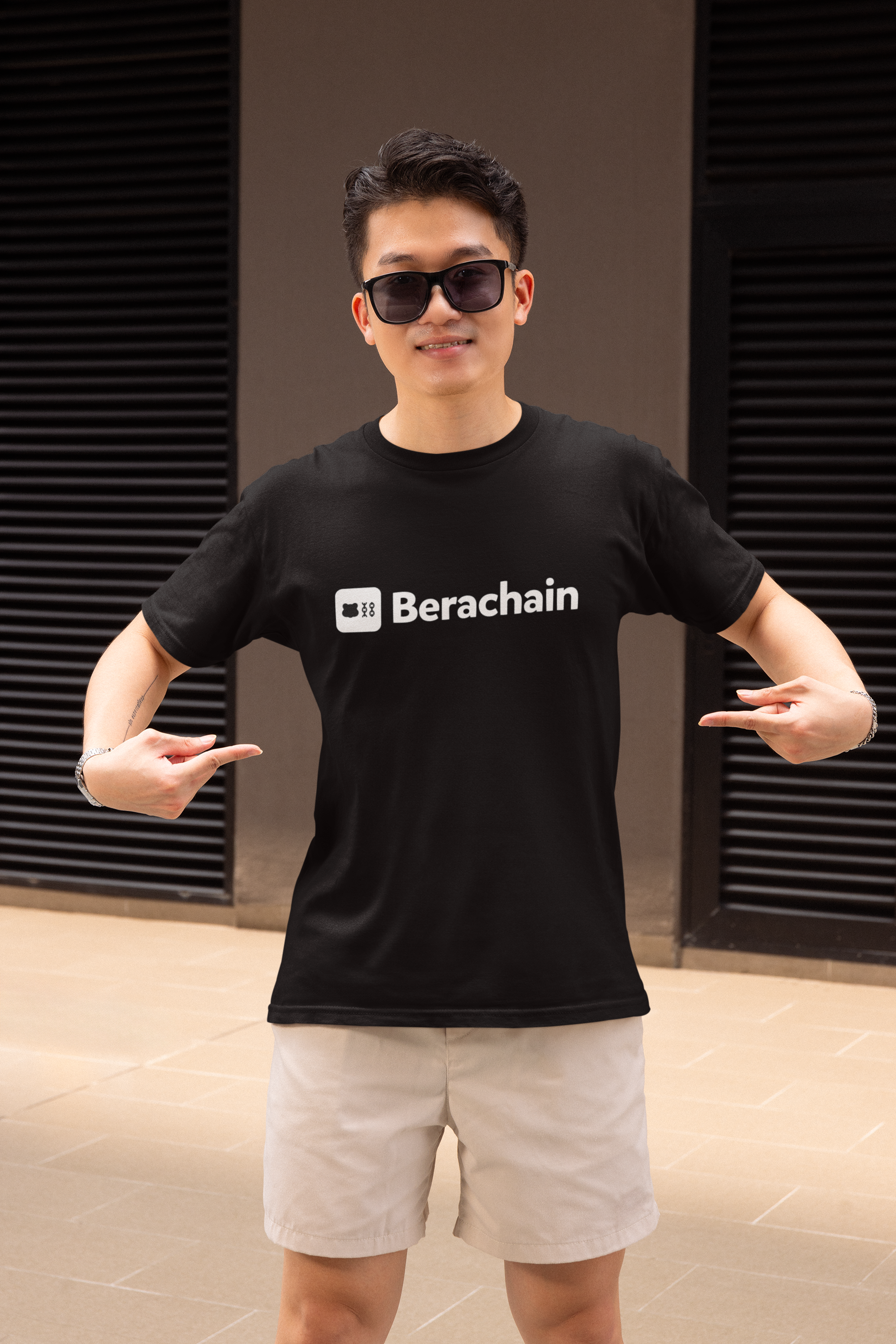 Person wearing a black t-shirt with 'Berachain' logo in an indoor setting
