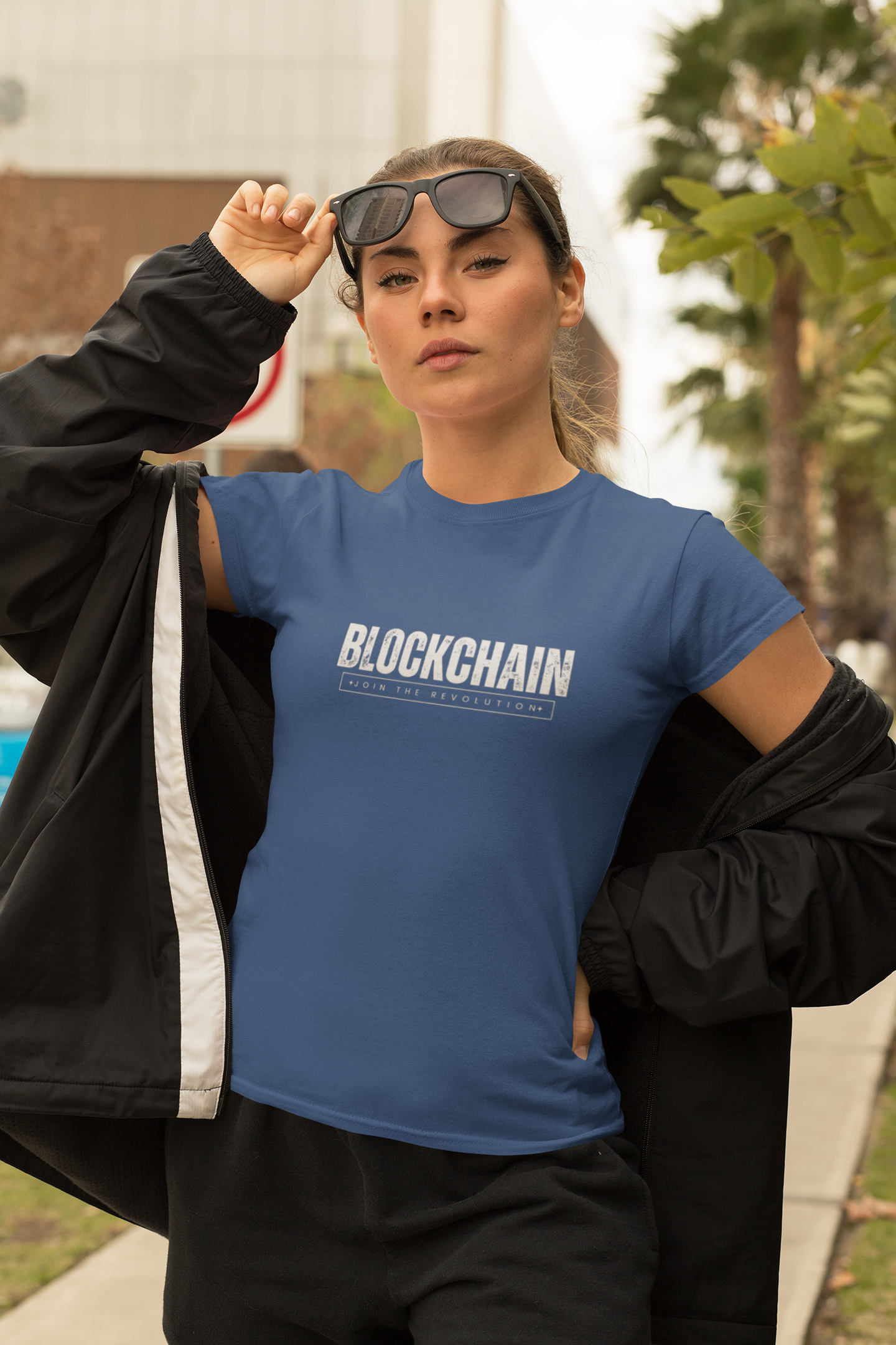 Person wearing a blue 'BLOCKCHAIN' t-shirt outdoors