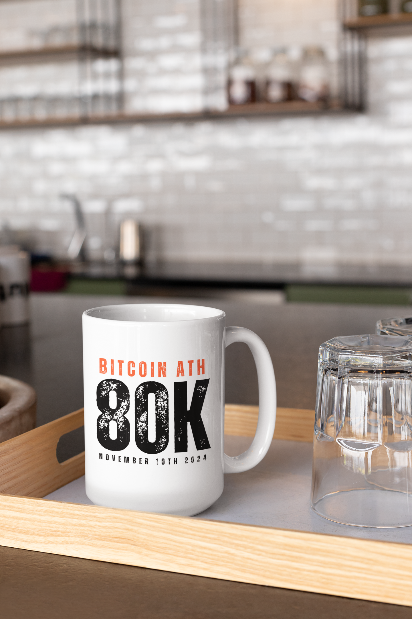White mug with Bitcoin ATH 80K text on a wooden tray in a kitchen setting