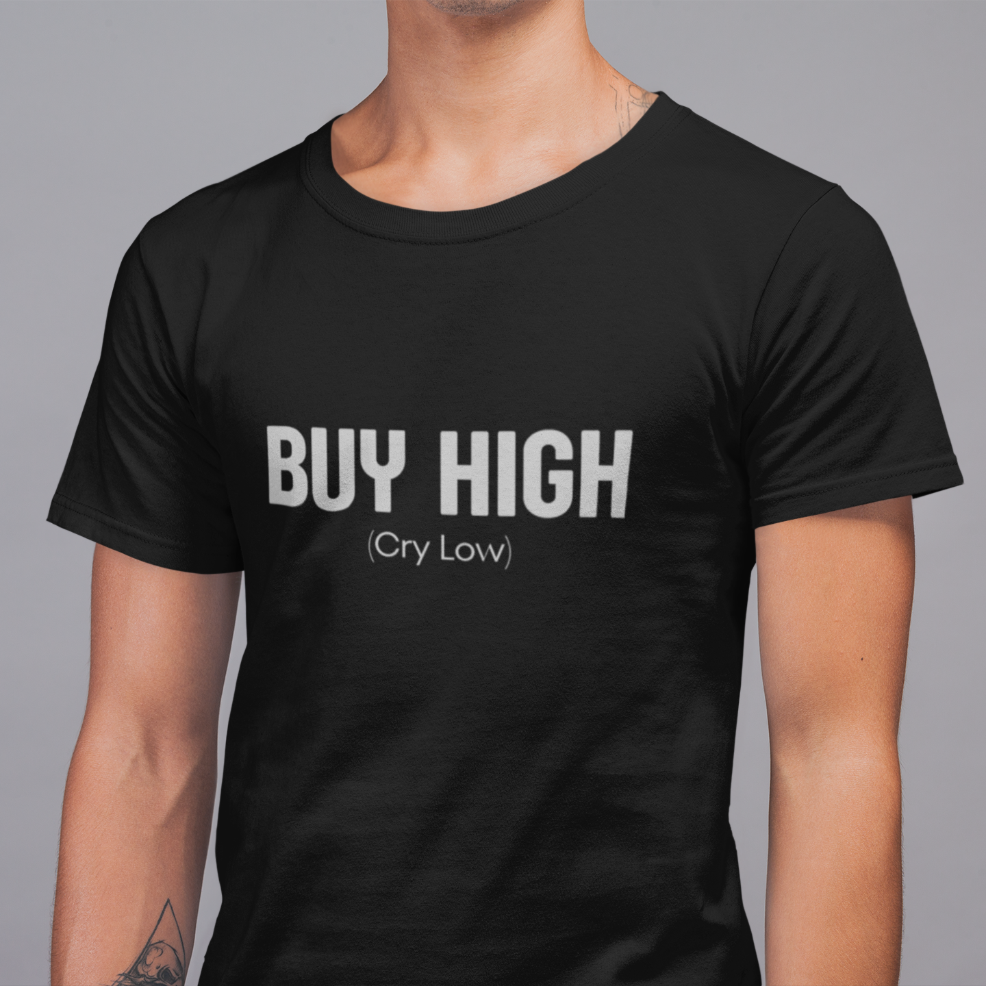 Person wearing a black t-shirt with 'BUY HIGH (Cry Low)' text on a gray background