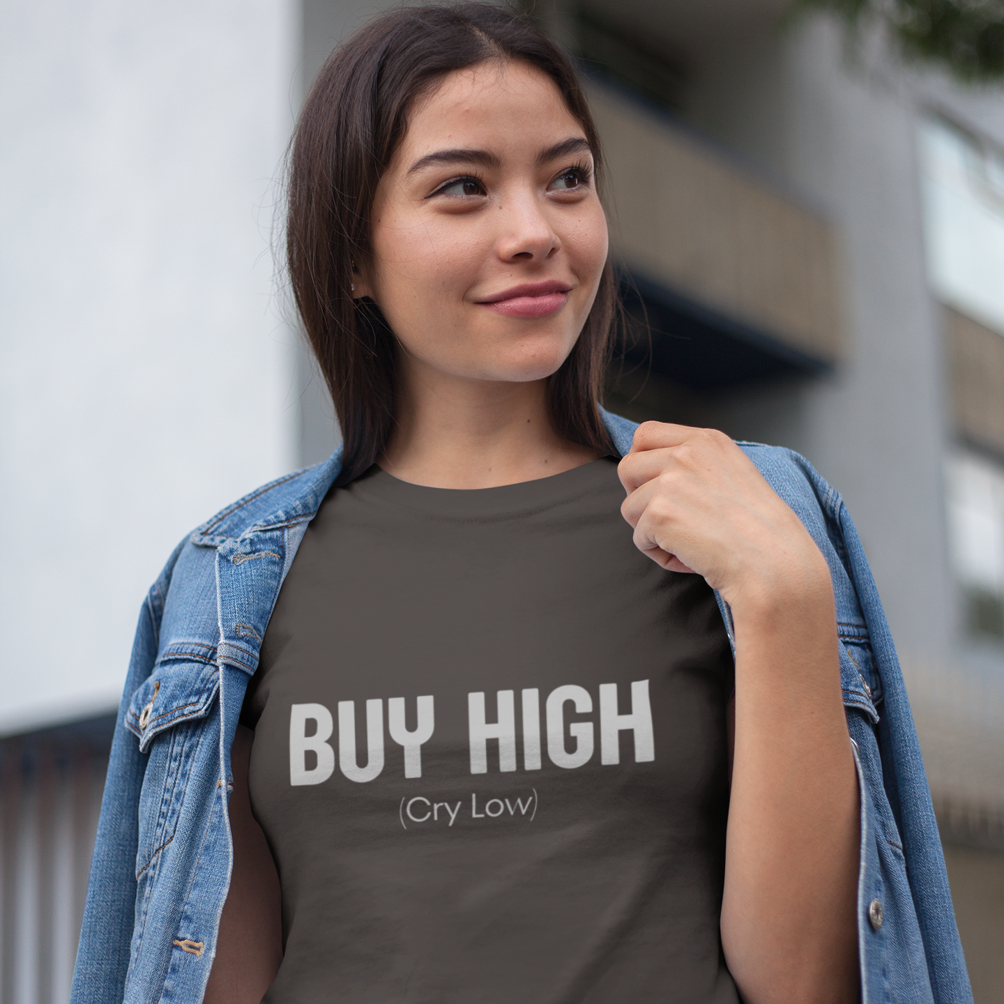 Person wearing a t-shirt with 'BUY HIGH (Cry Low)' text outdoors.