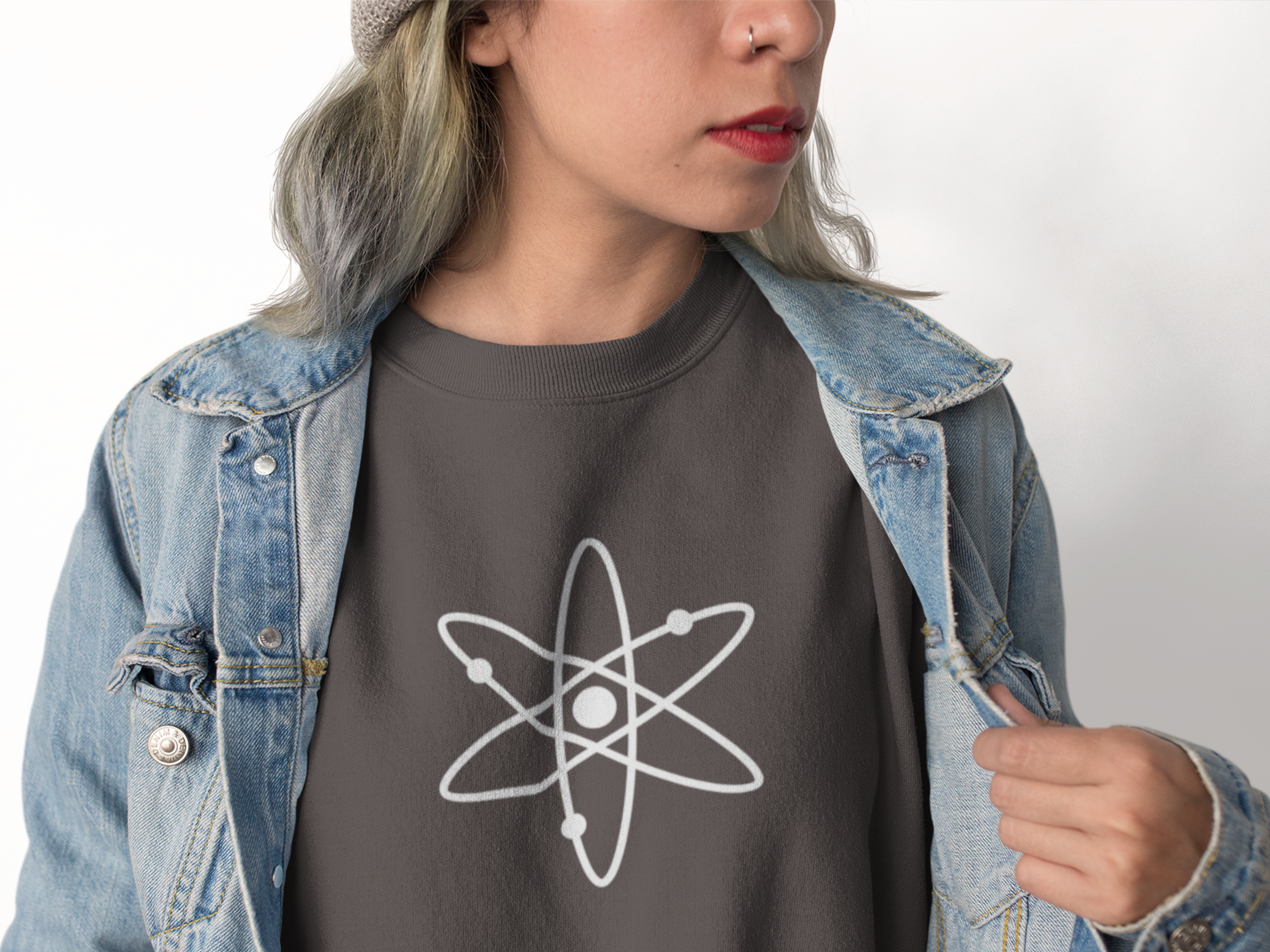 Person wearing a dark gray t-shirt with an atom symbol design, paired with a denim jacket.
