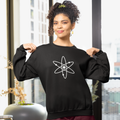 Woman wearing a black sweatshirt with a white atom symbol in a modern indoor setting.