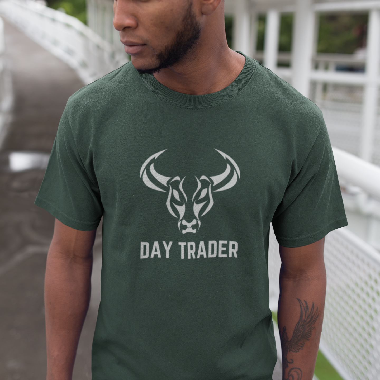 Man wearing a green t-shirt with a bull logo and 'DAY TRADER' text on a bridge.