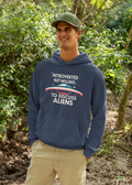 Person wearing a navy hoodie with alien-themed text in a forest setting
