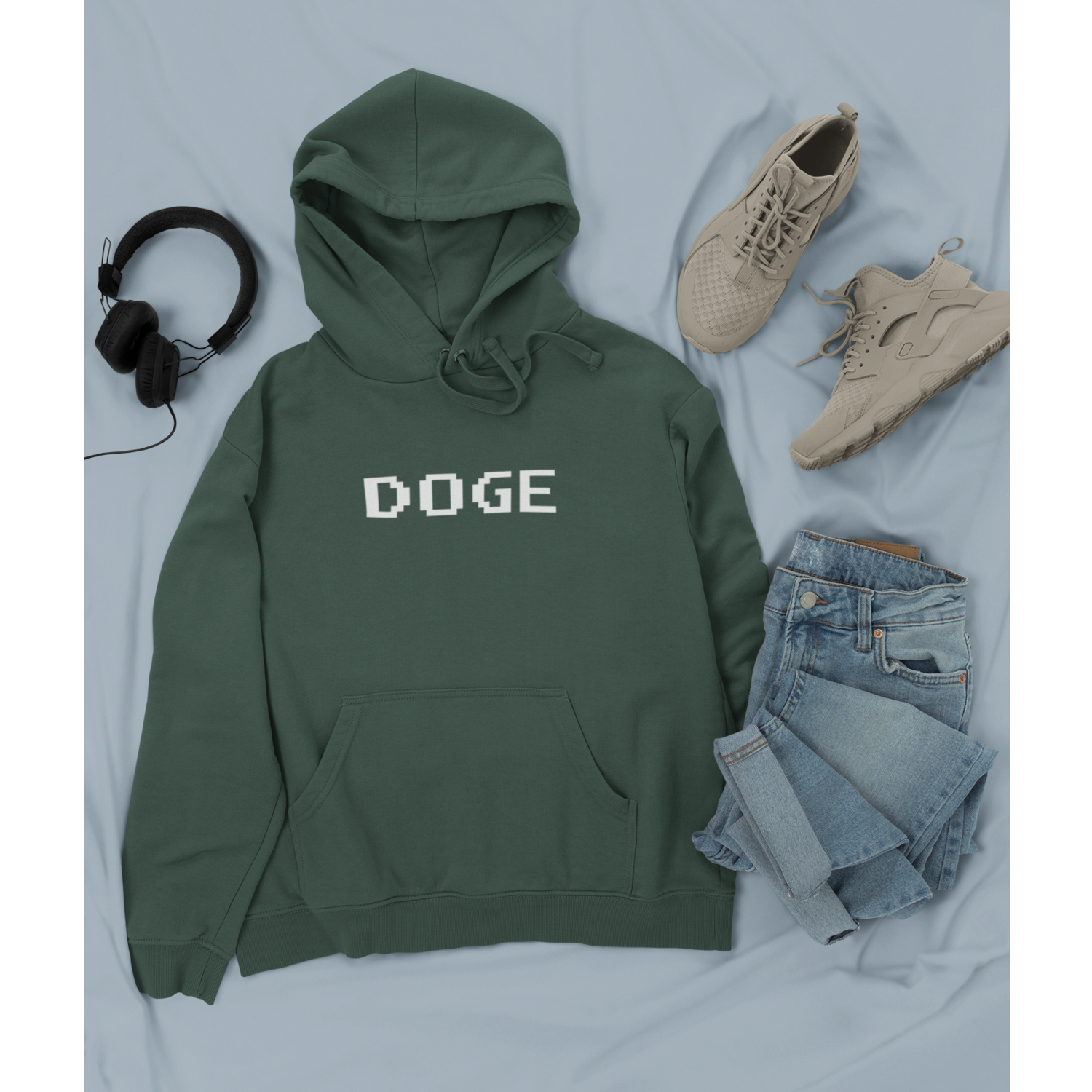 Green hoodie with 'DOGE' text, paired with jeans, sneakers, and headphones on a light gray background.