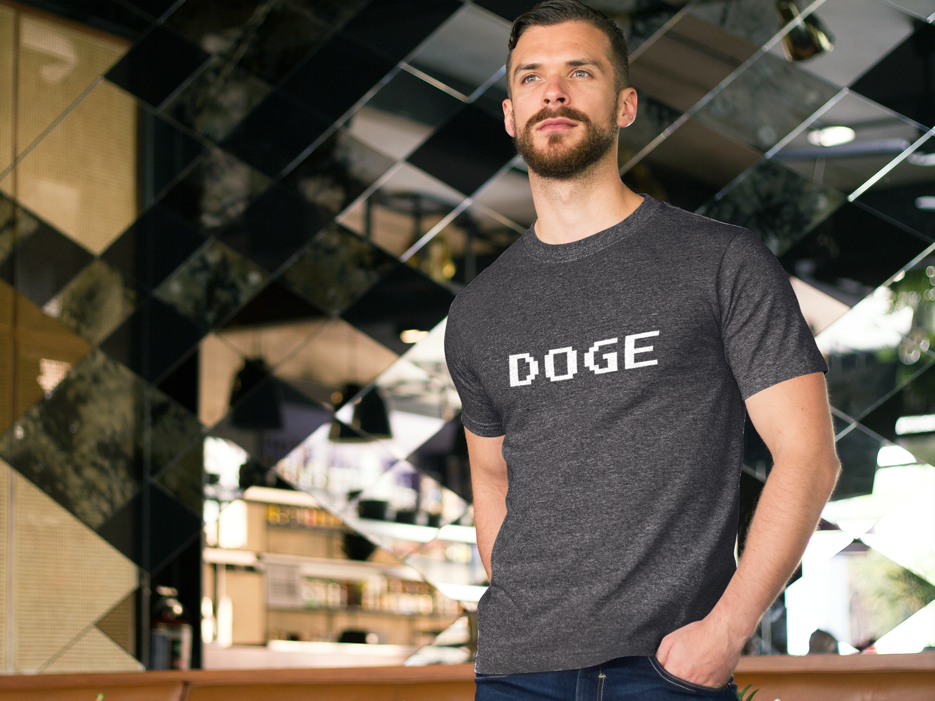 Man wearing a gray t-shirt with 'DOGE' printed on it, standing in front of a reflective wall.