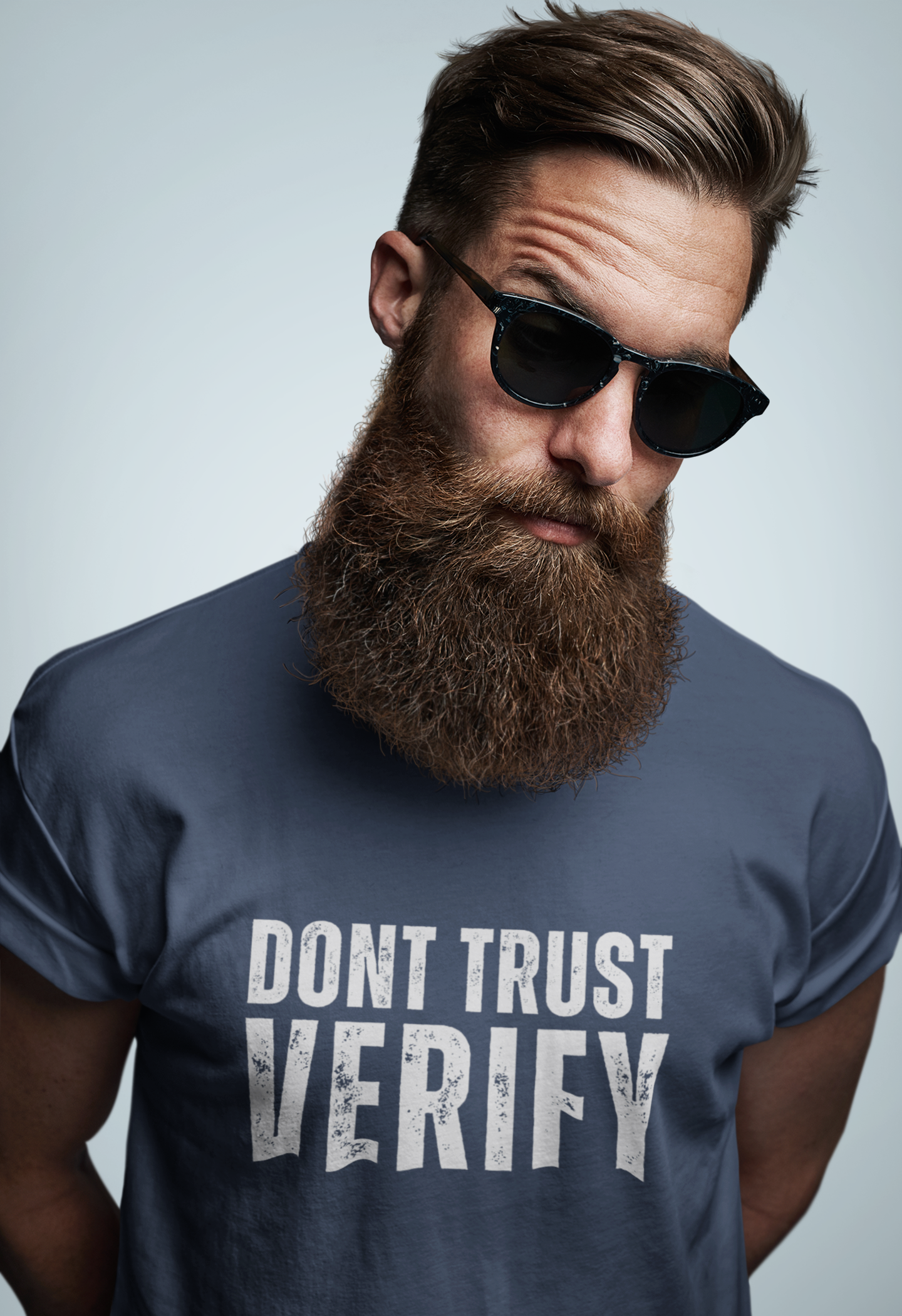 Man wearing sunglasses and a t-shirt with 'DON'T TRUST VERIFY' text on a plain background