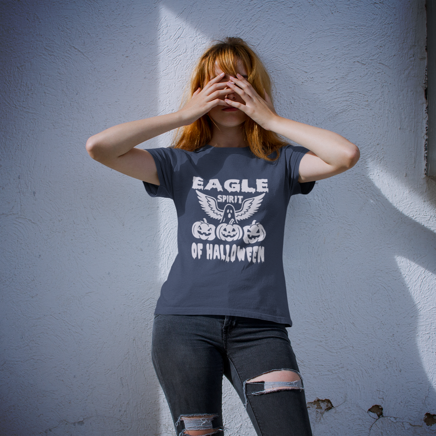 Person wearing a t-shirt with Halloween design against a white wall