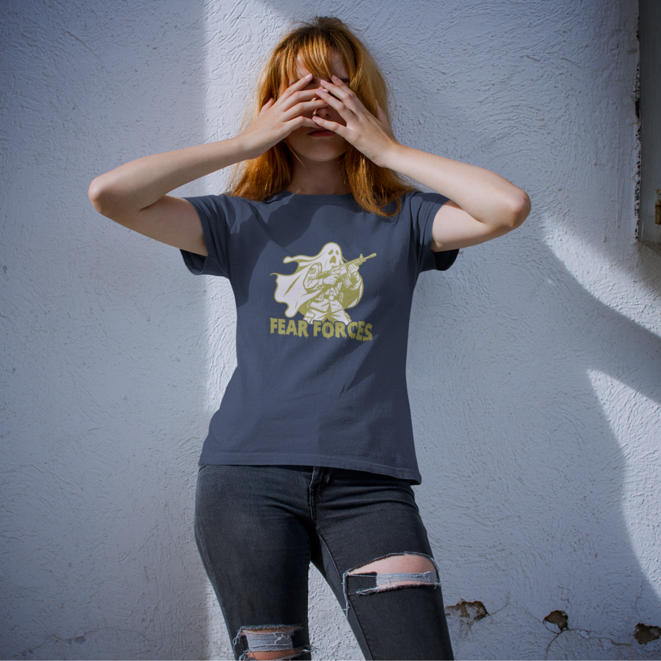 Person wearing a t-shirt with a graphic design against a white wall