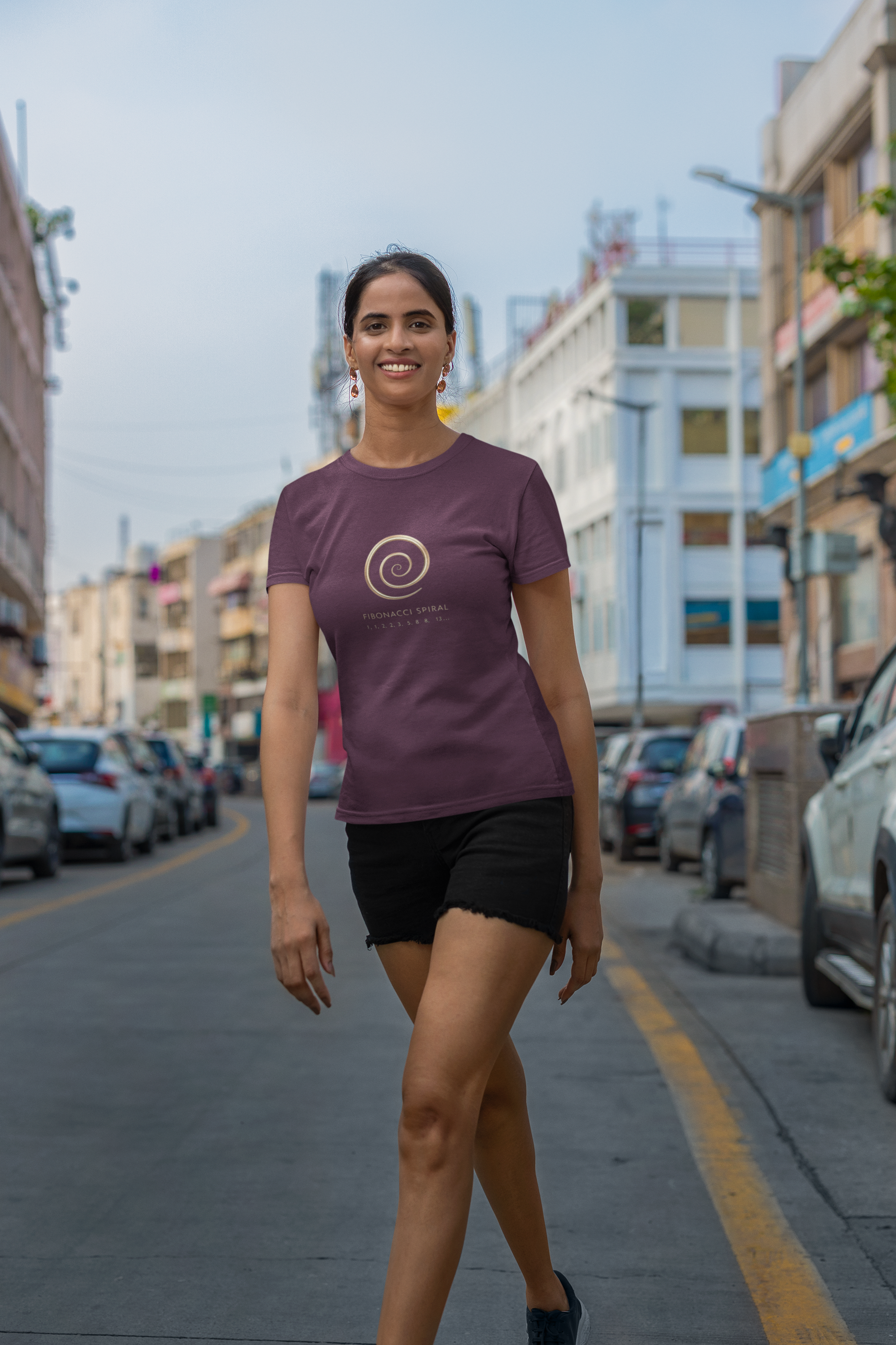 Woman wearing a purple t-shirt with a logo on a city street