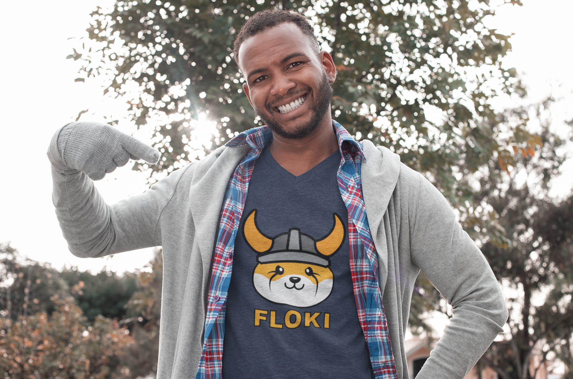 Man wearing a t-shirt with a dog graphic and 'FLOKI' text outdoors
