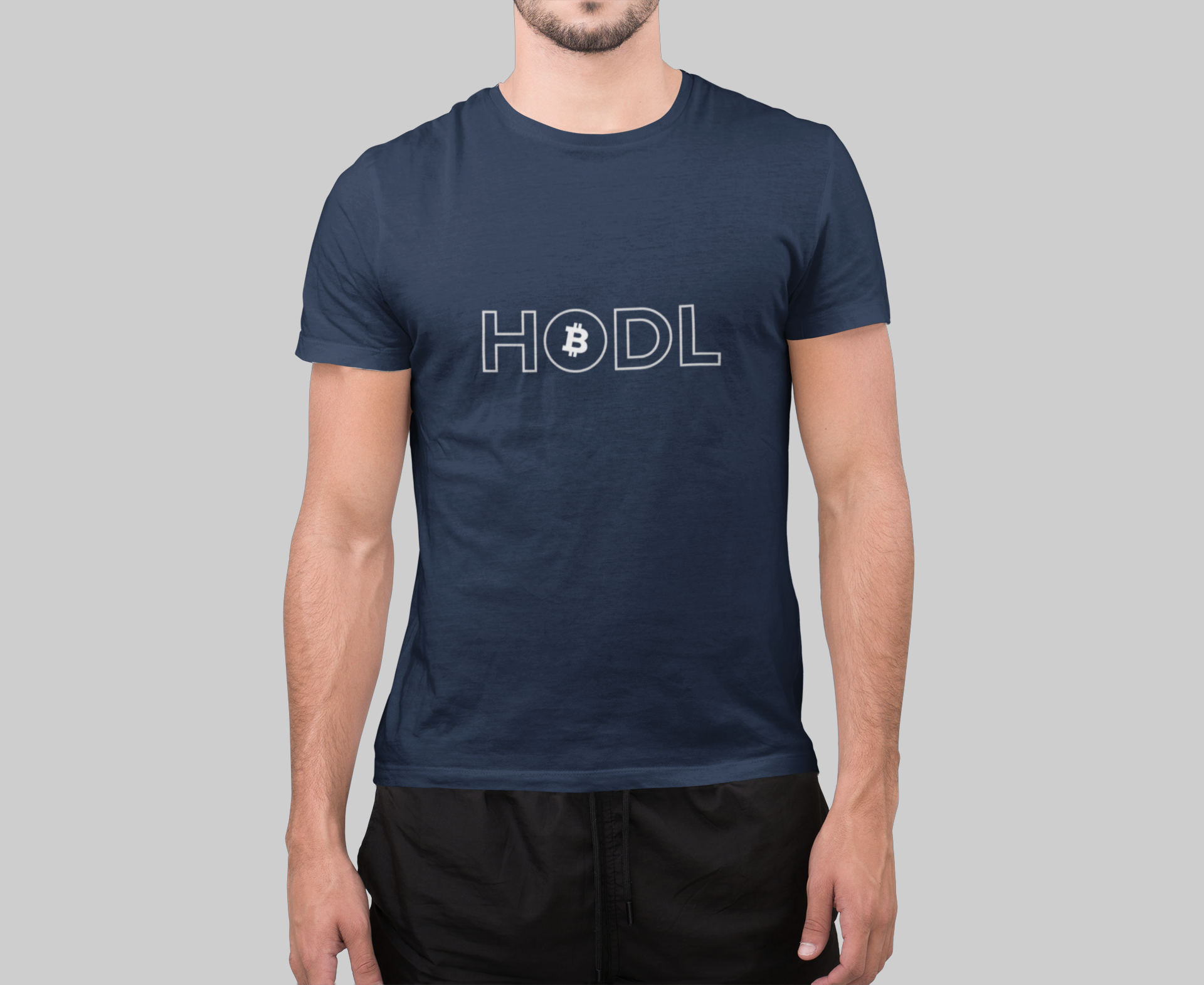 Person wearing a navy blue t-shirt with 'HODL' printed on it against a gray background