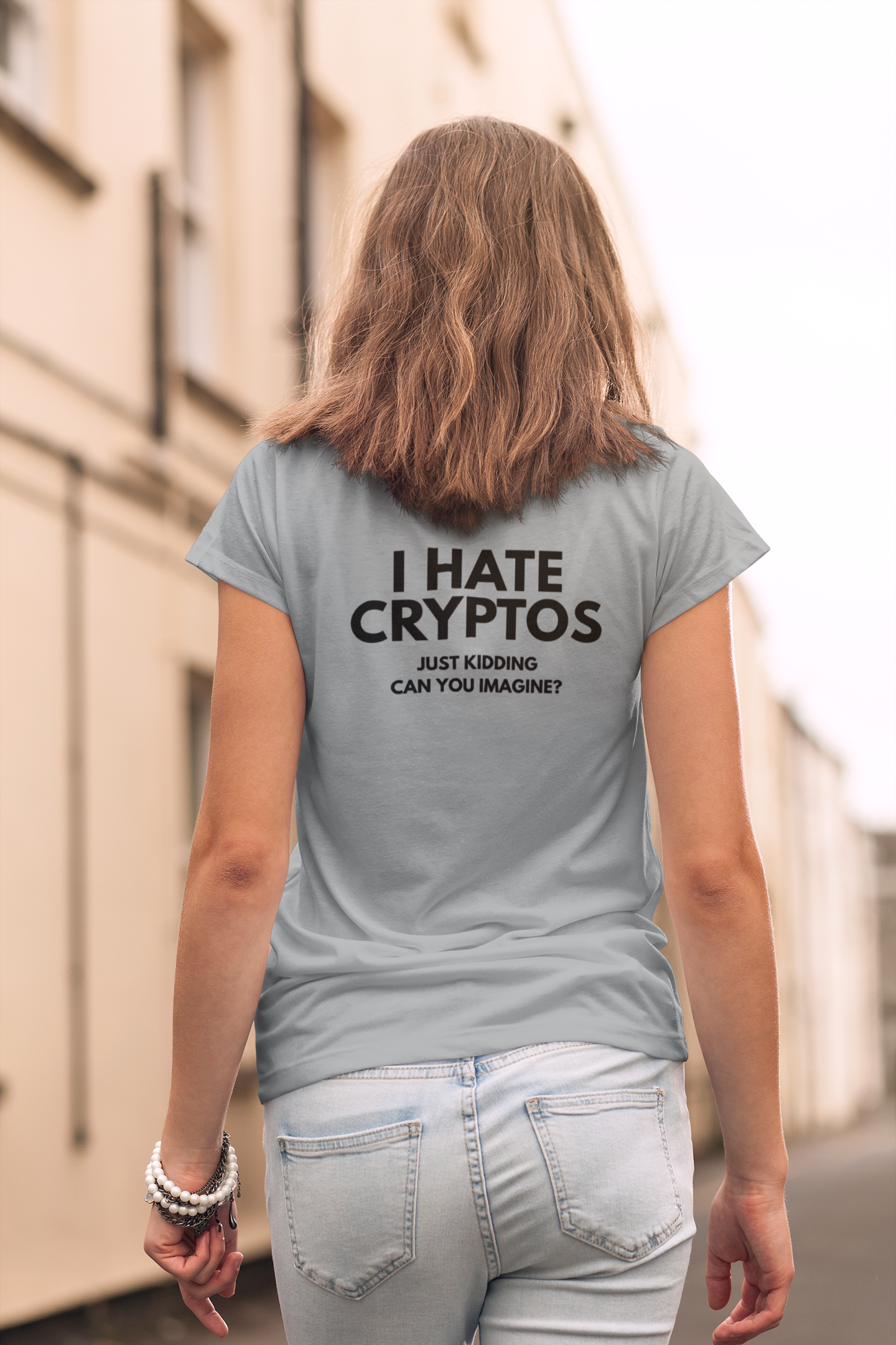 Person wearing a t-shirt with humorous text about cryptos on a city street.