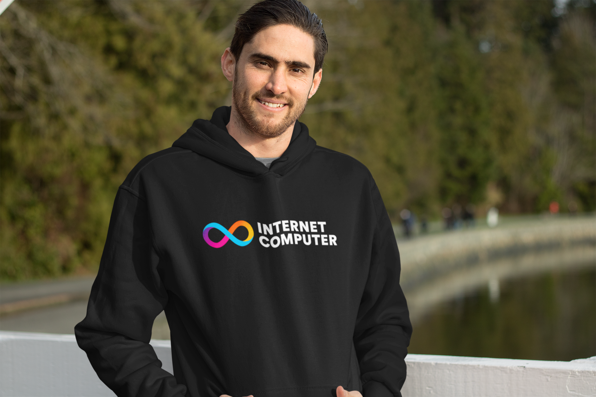 Person wearing a black hoodie with 'Internet Computer' logo outdoors