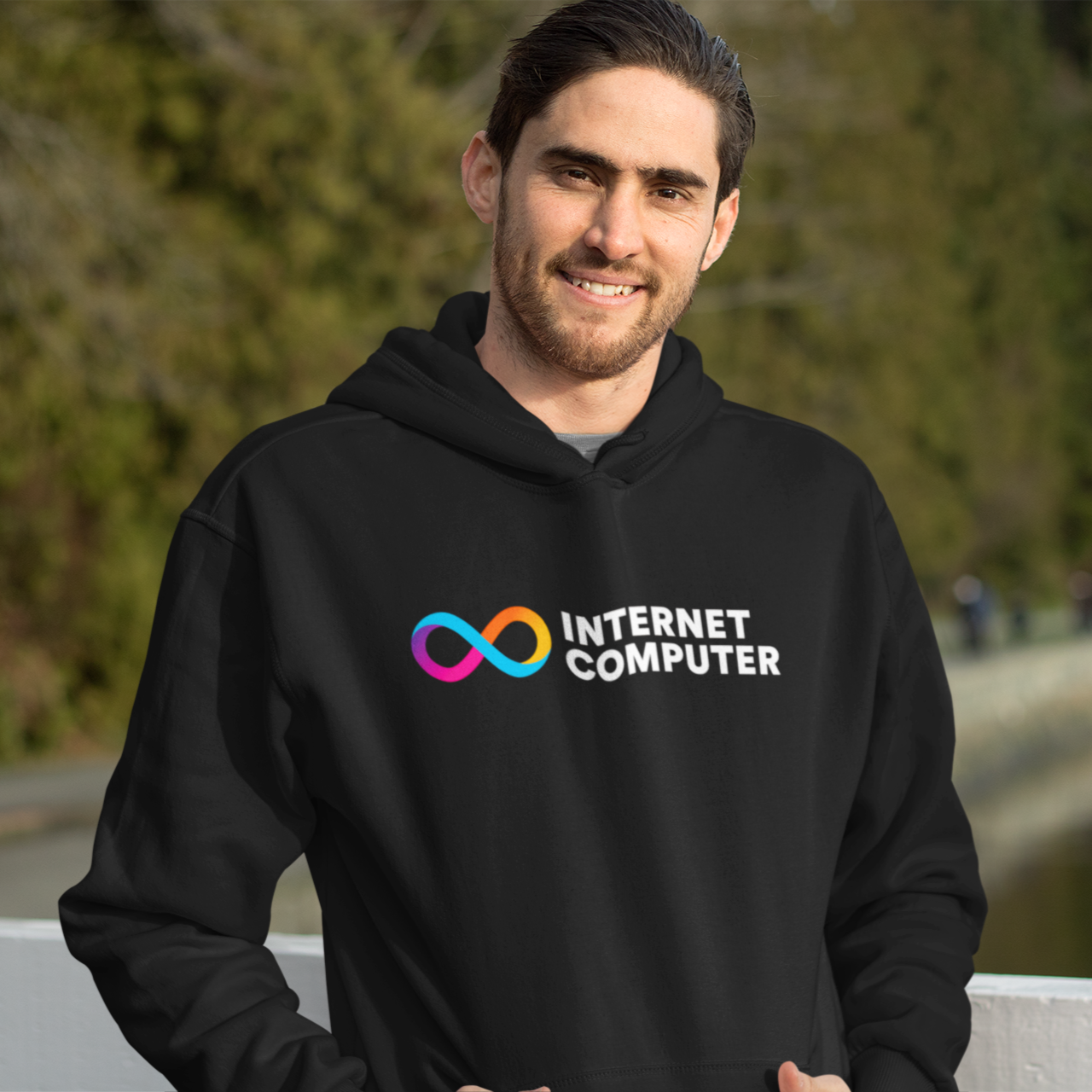 Person wearing a black hoodie with 'Internet Computer' logo outdoors