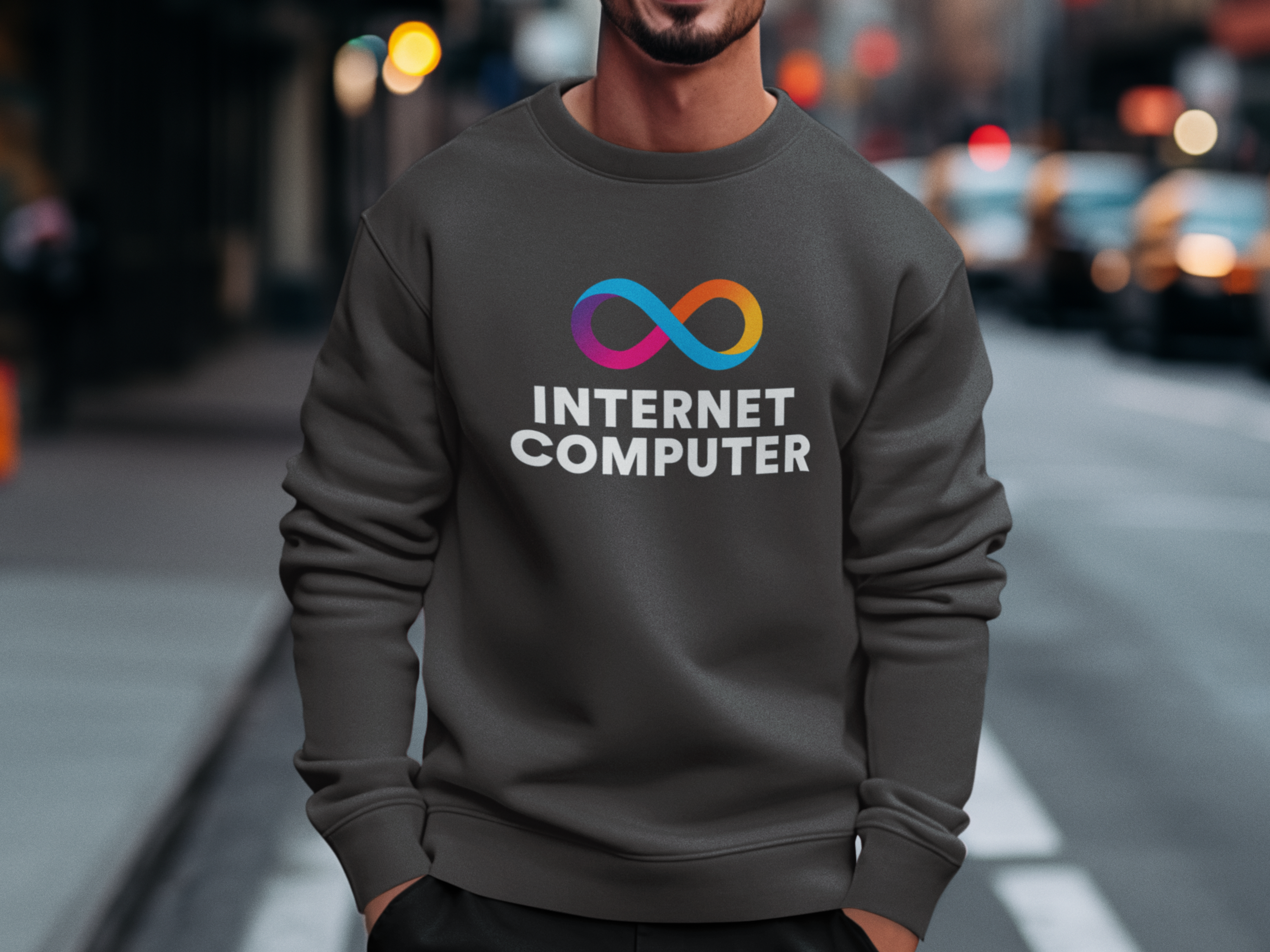 Person wearing a dark gray sweatshirt with 'Internet Computer' logo on a city street.
