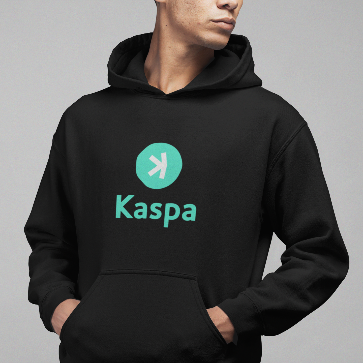 Person wearing a black hoodie with Kaspa logo on a gray background