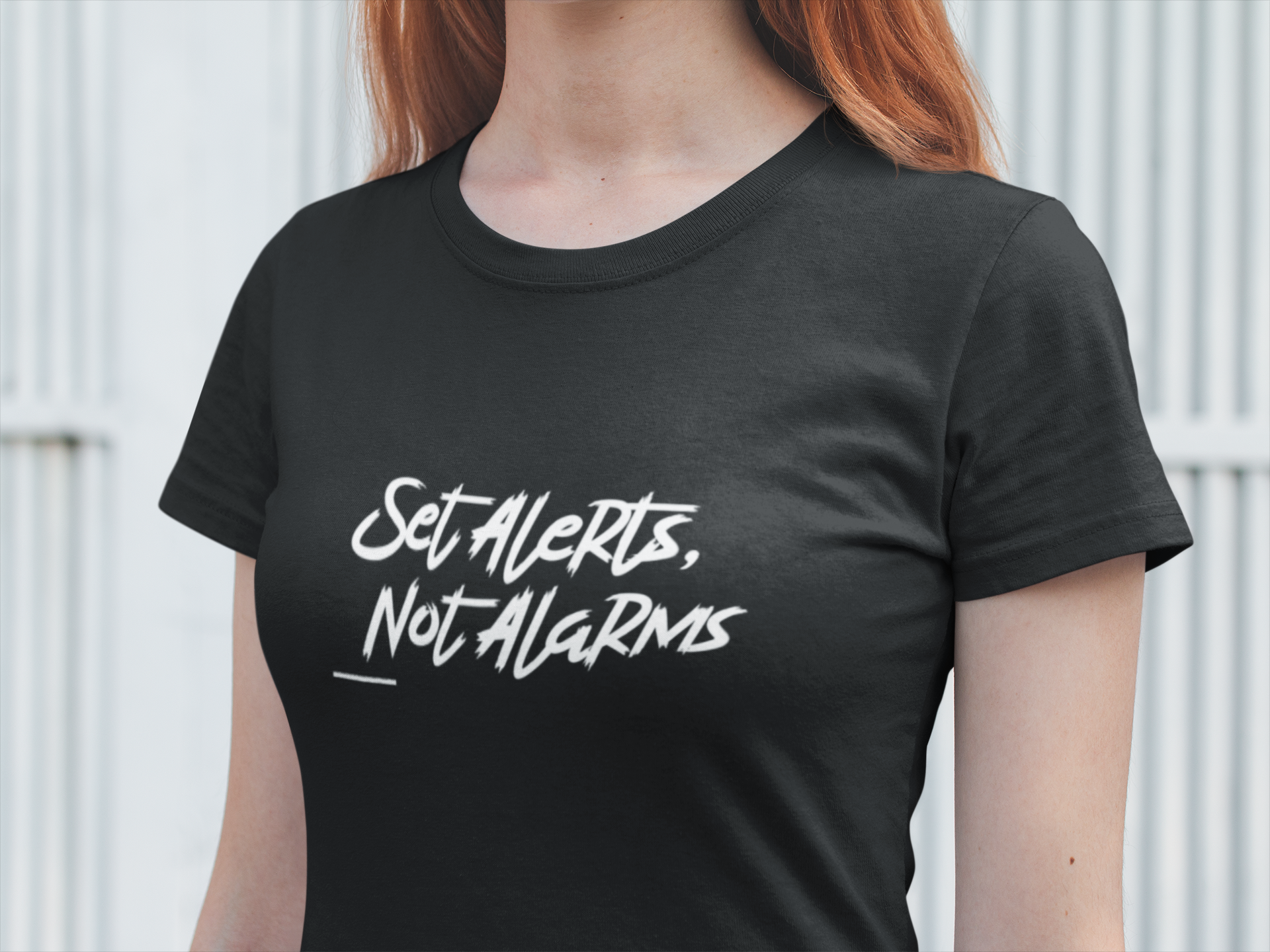 Person wearing a black t-shirt with 'Set Alerts, Not Alarms' text.