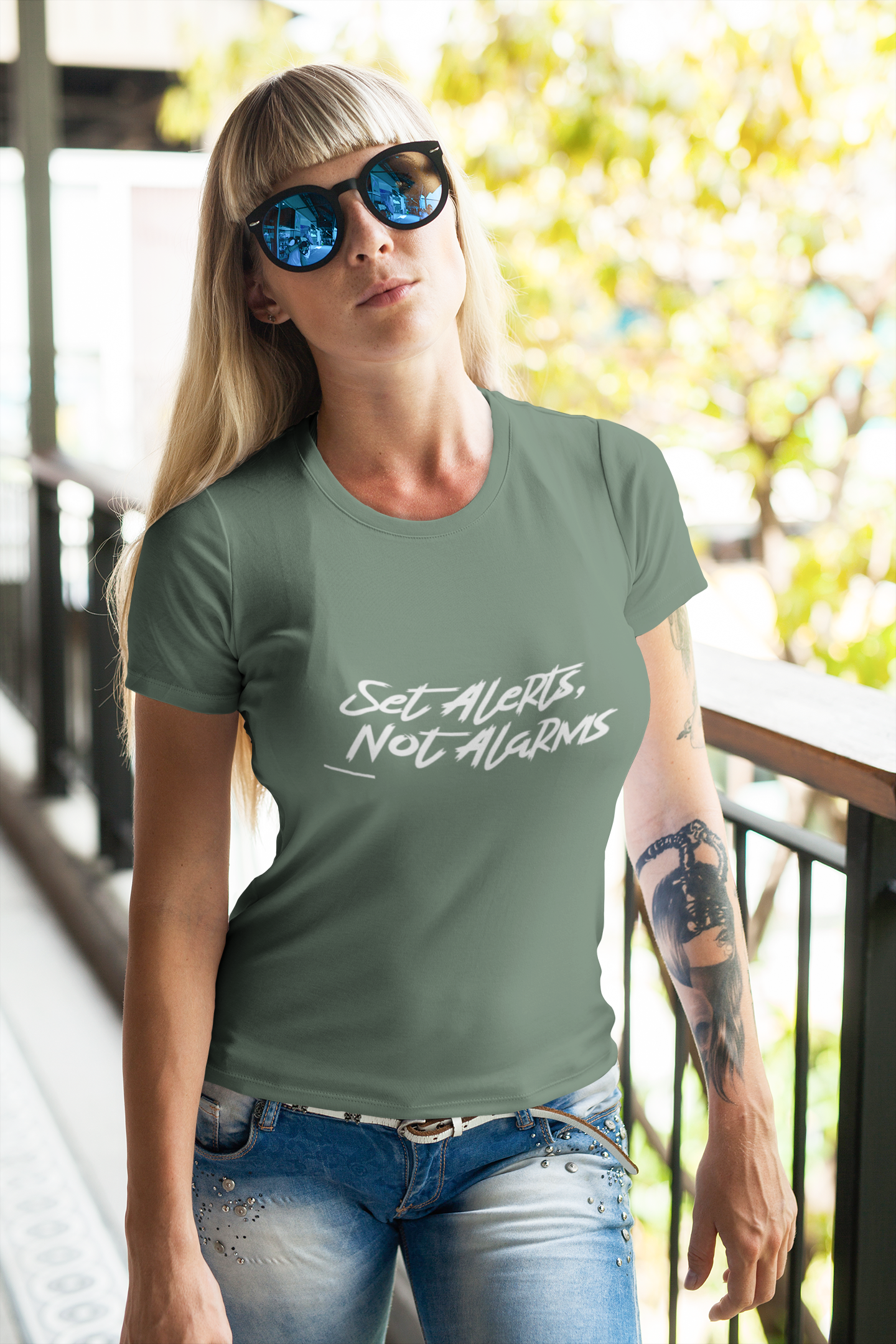 Woman wearing a green t-shirt with text, standing outdoors.