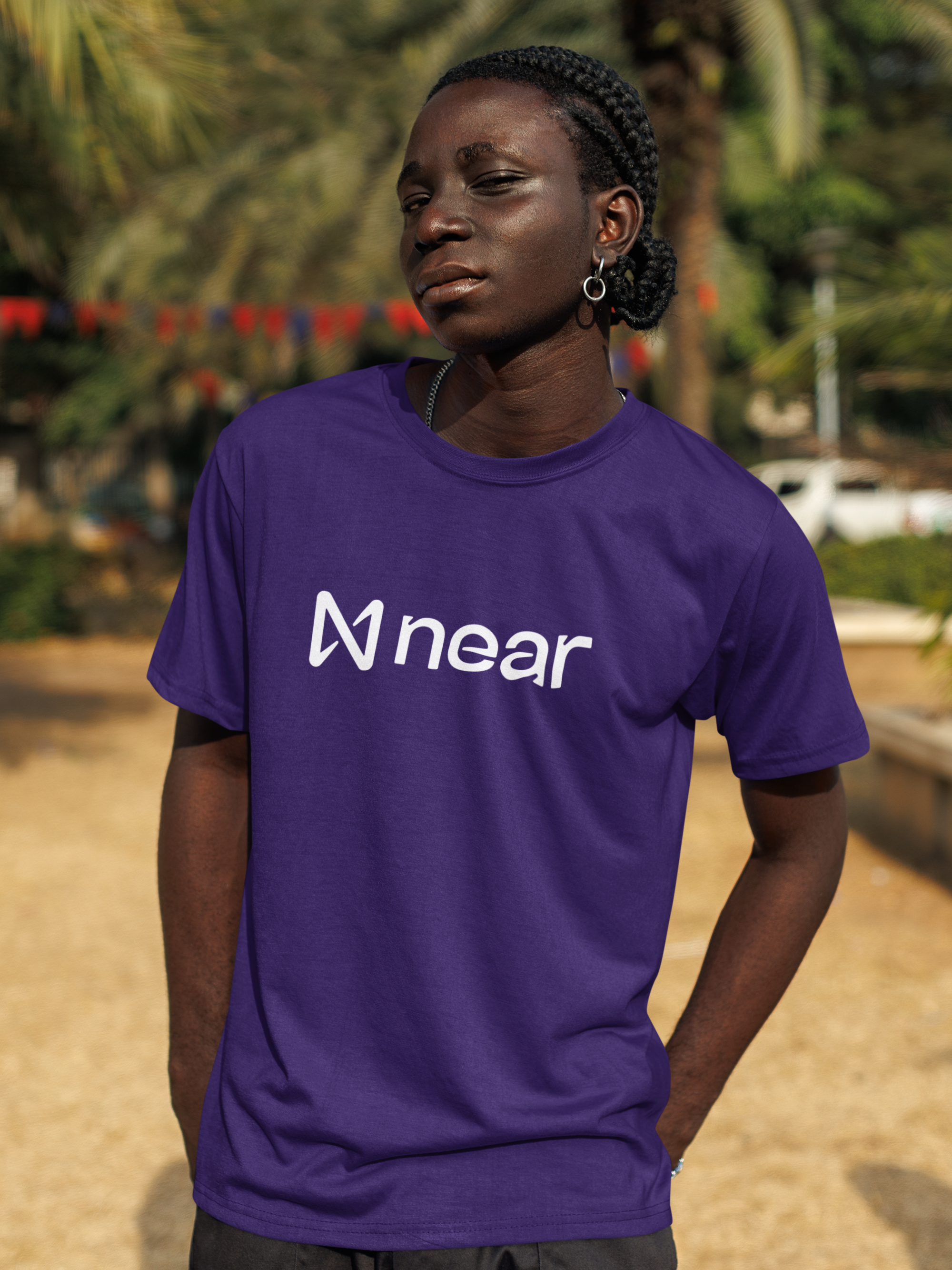 Person wearing a purple t-shirt with 'near' logo outdoors