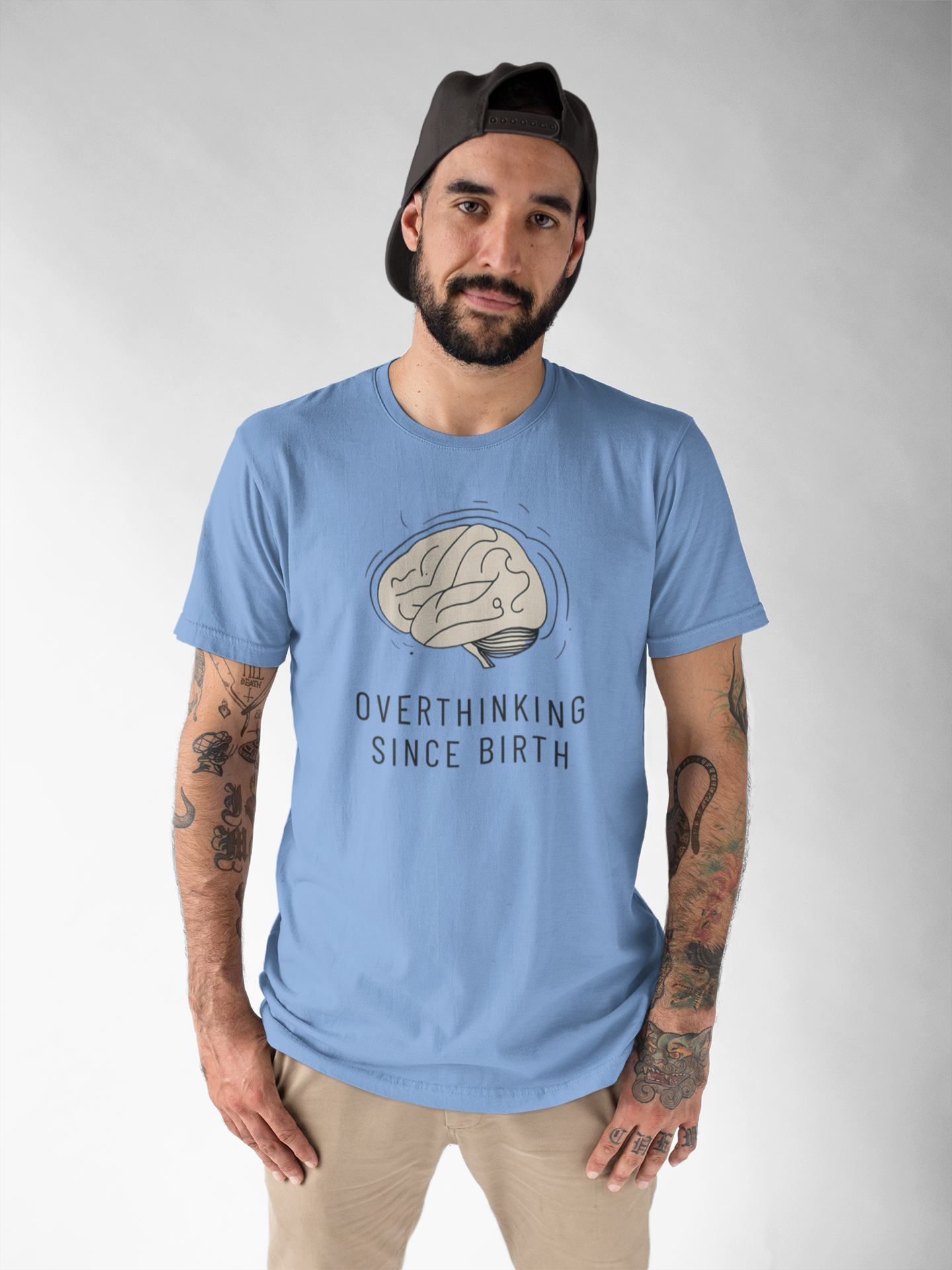 Man wearing a light blue t-shirt with a graphic design and text on a plain background