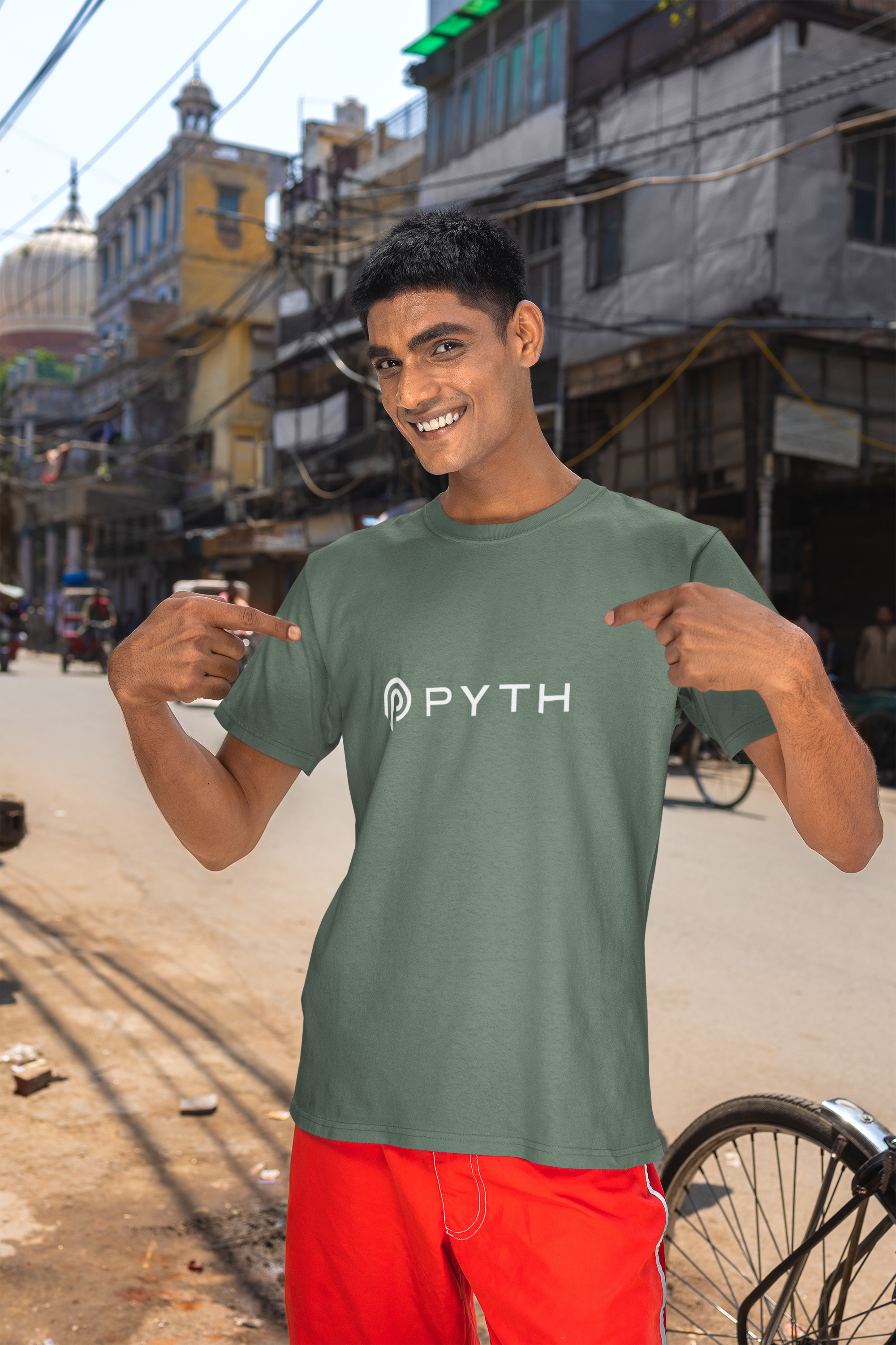Man wearing a green t-shirt with 'PYTH' logo in an urban setting
