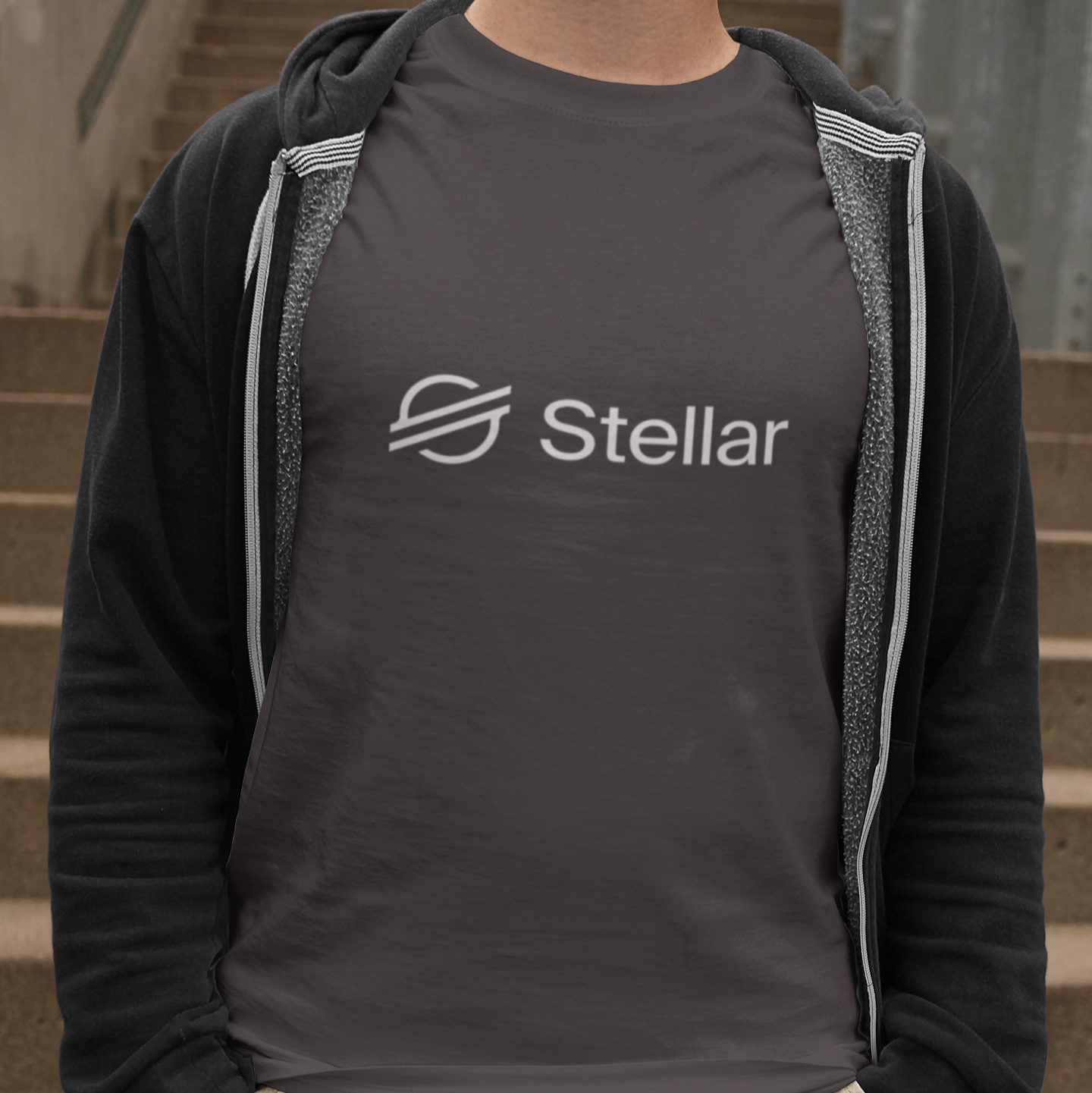 Person wearing a dark hoodie with 'Stellar' logo on a staircase background