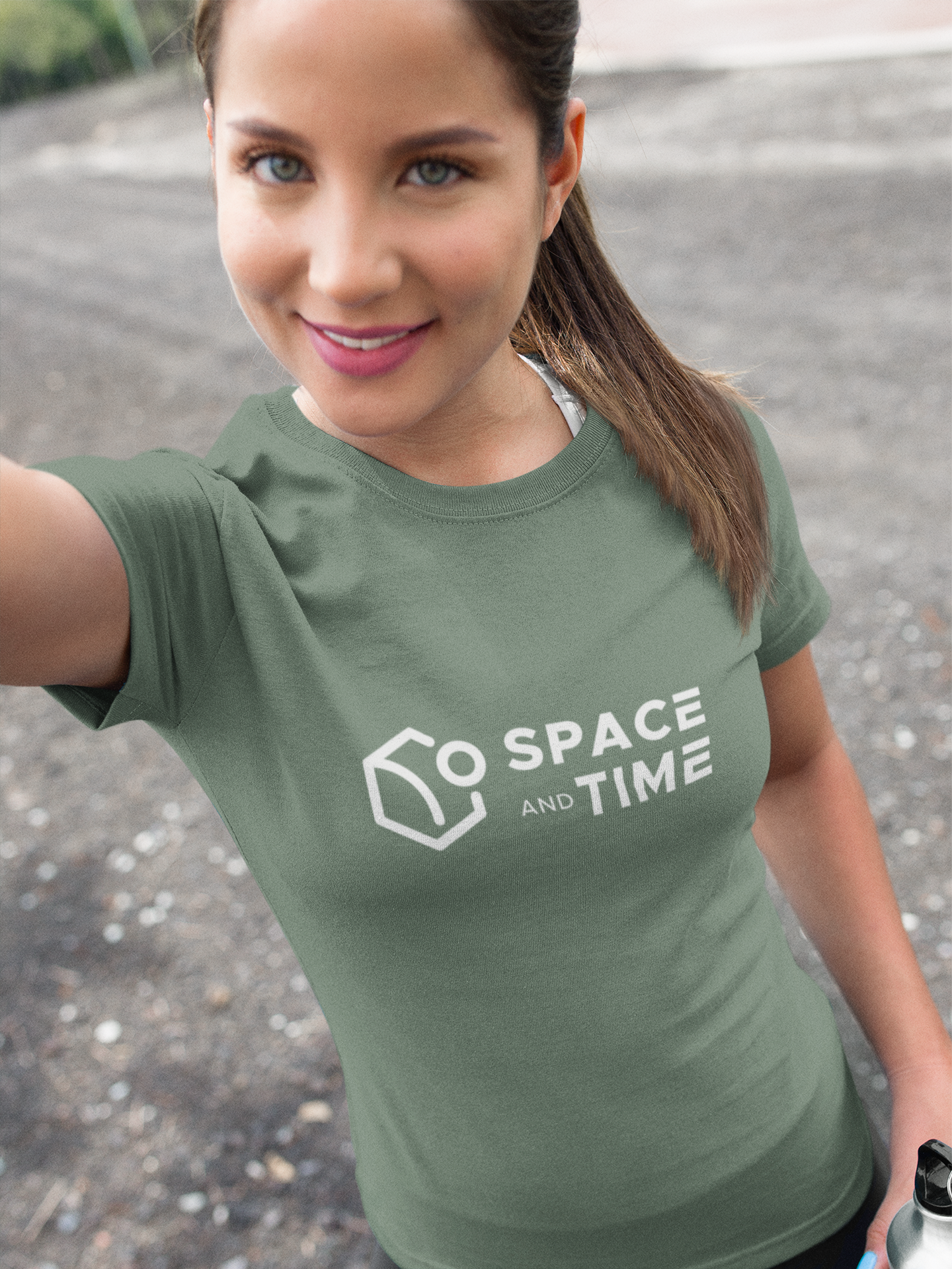 Woman wearing a green t-shirt with 'Space and Time' logo outdoors.