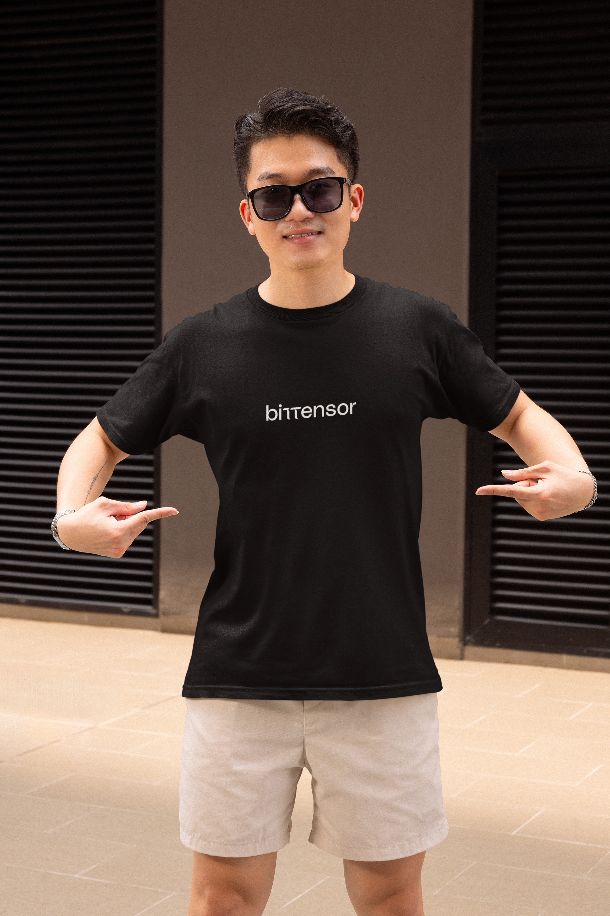 Person wearing a black t-shirt with 'bitensor' logo and sunglasses, posing in front of a dark background.