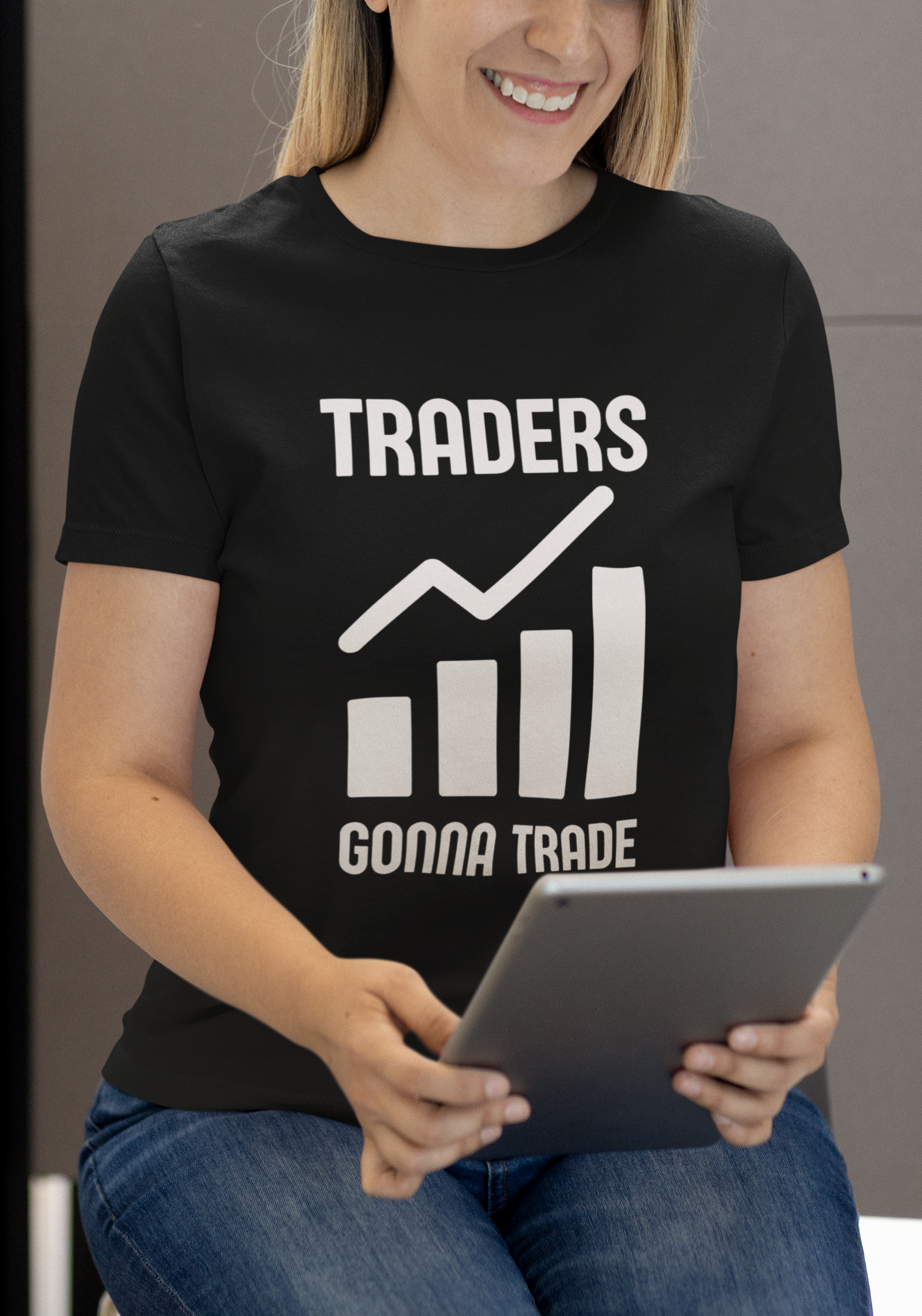 Person wearing a black t-shirt with 'TRADERS GONNA TRADE' text and holding a tablet.