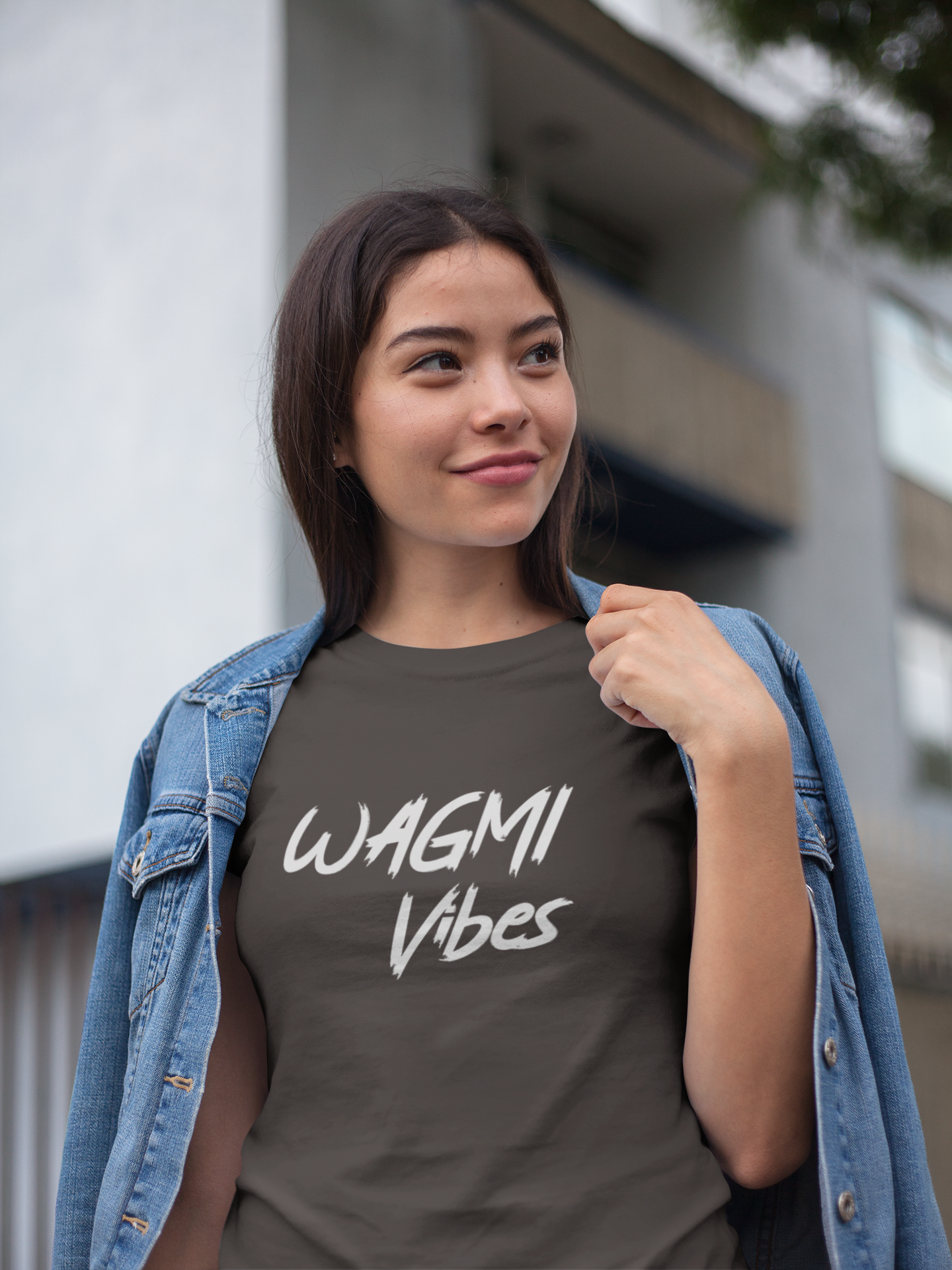 Woman wearing a dark gray t-shirt with 'WAGMI Vibes' text, standing outdoors.