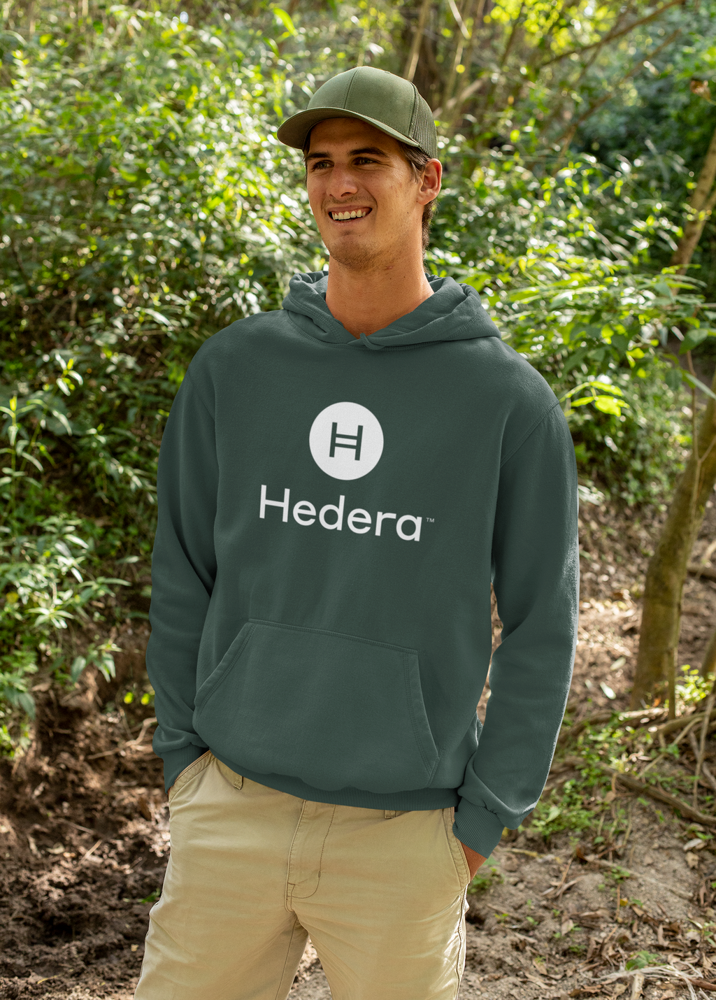 Person wearing a Hedera hoodie in a forest setting