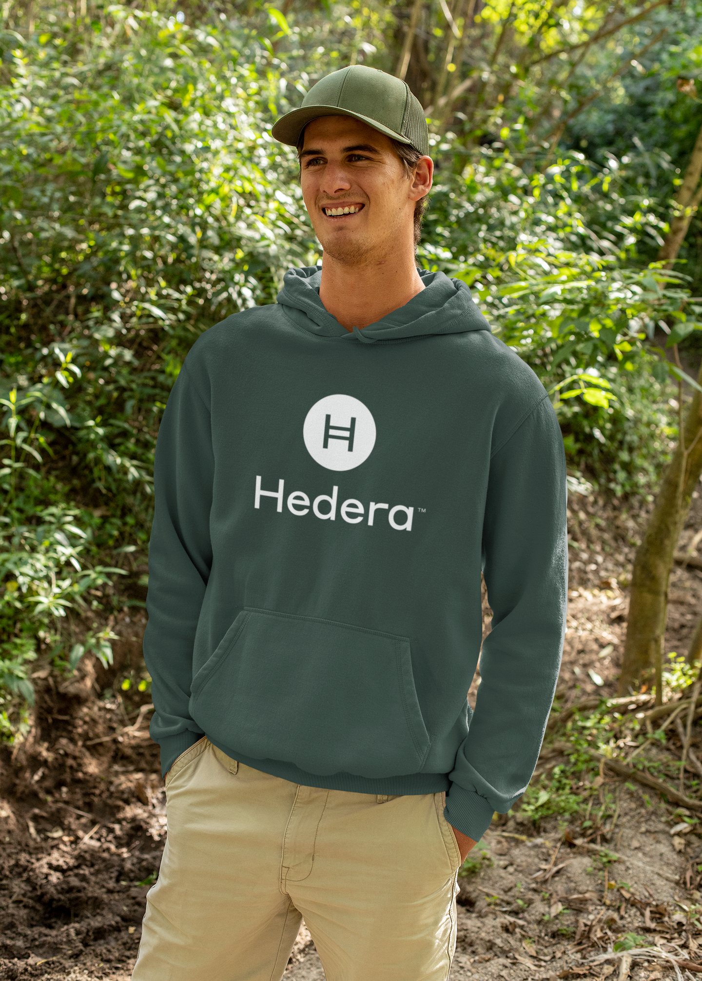 Person wearing a Hedera hoodie in a forest setting