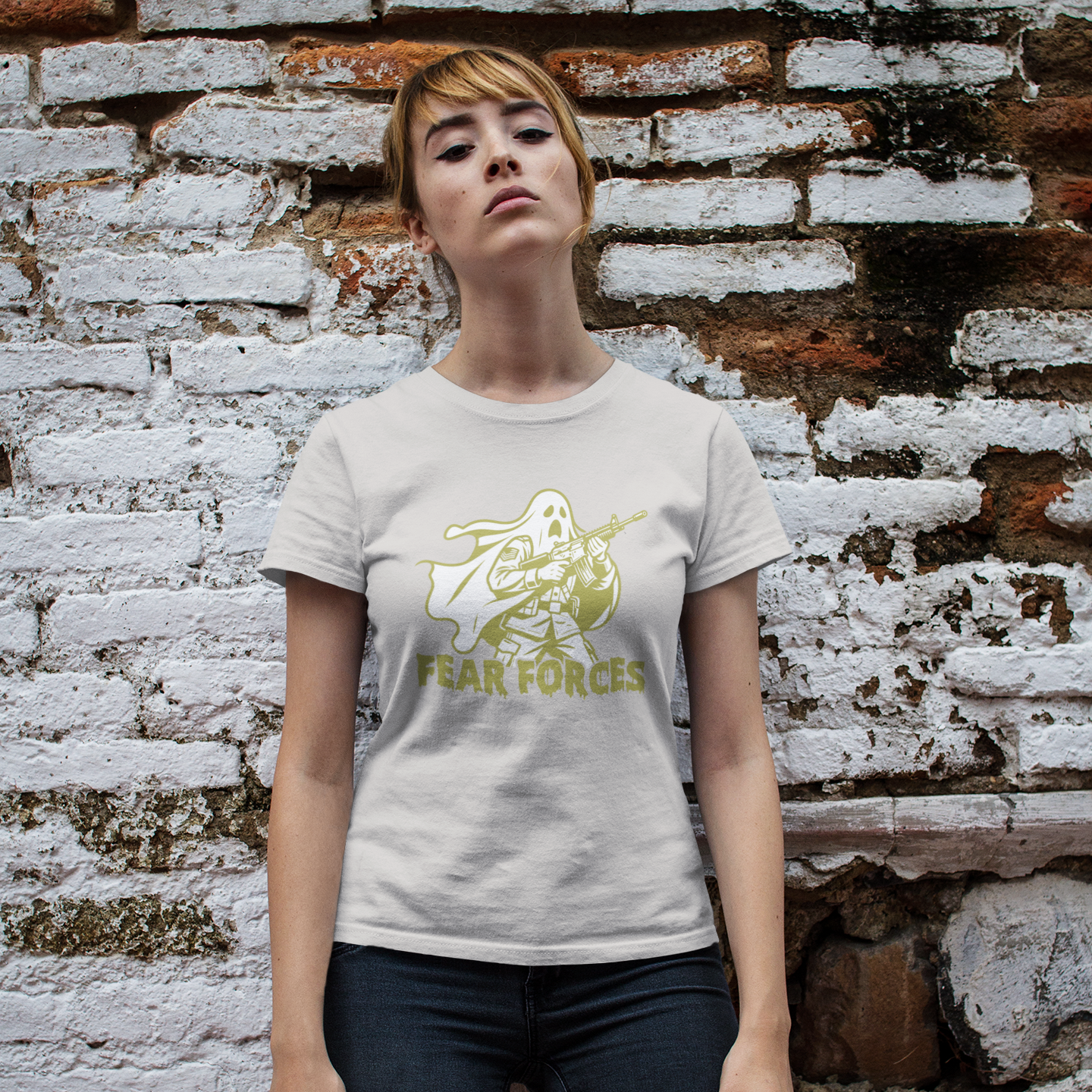 Person wearing a white t-shirt with a graphic design and text, standing against a textured brick wall.