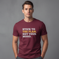 Man wearing a maroon t-shirt with motivational text on a gray background