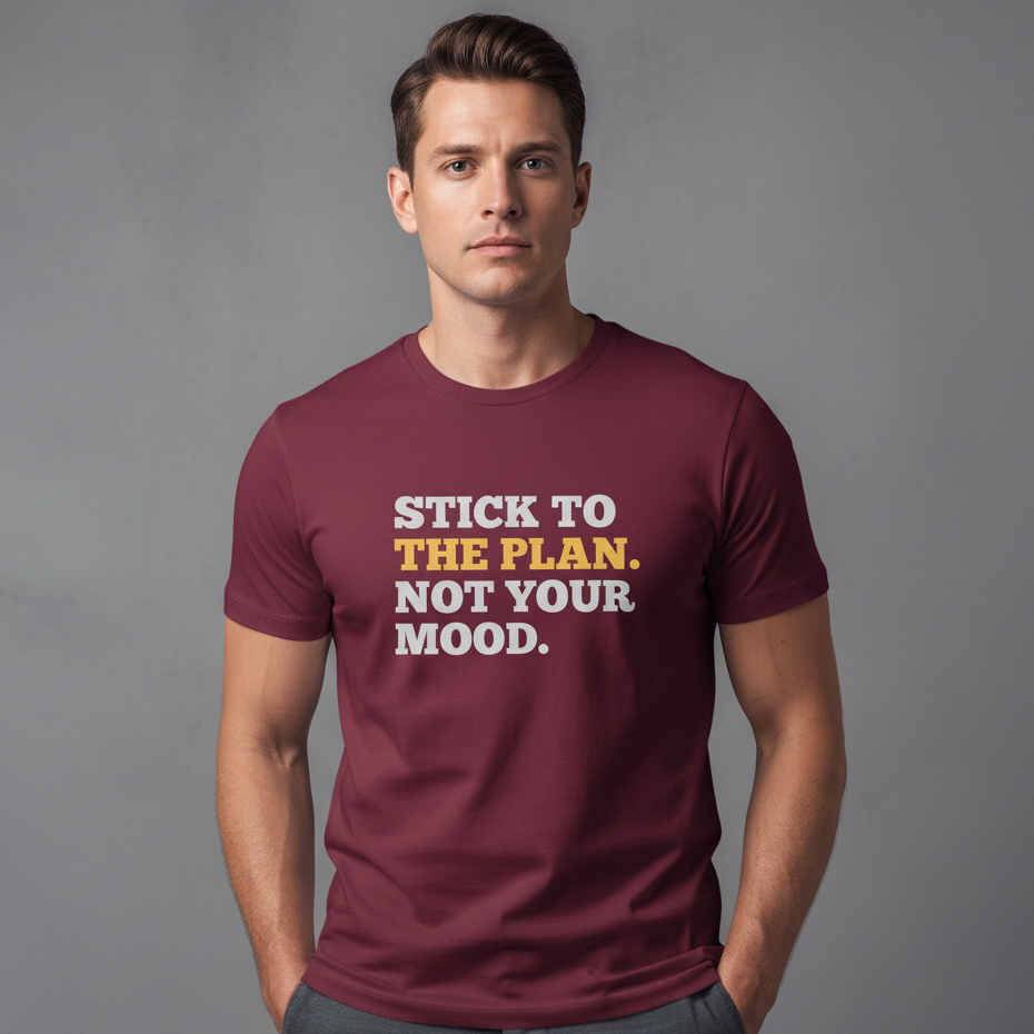 Man wearing a maroon t-shirt with motivational text on a gray background