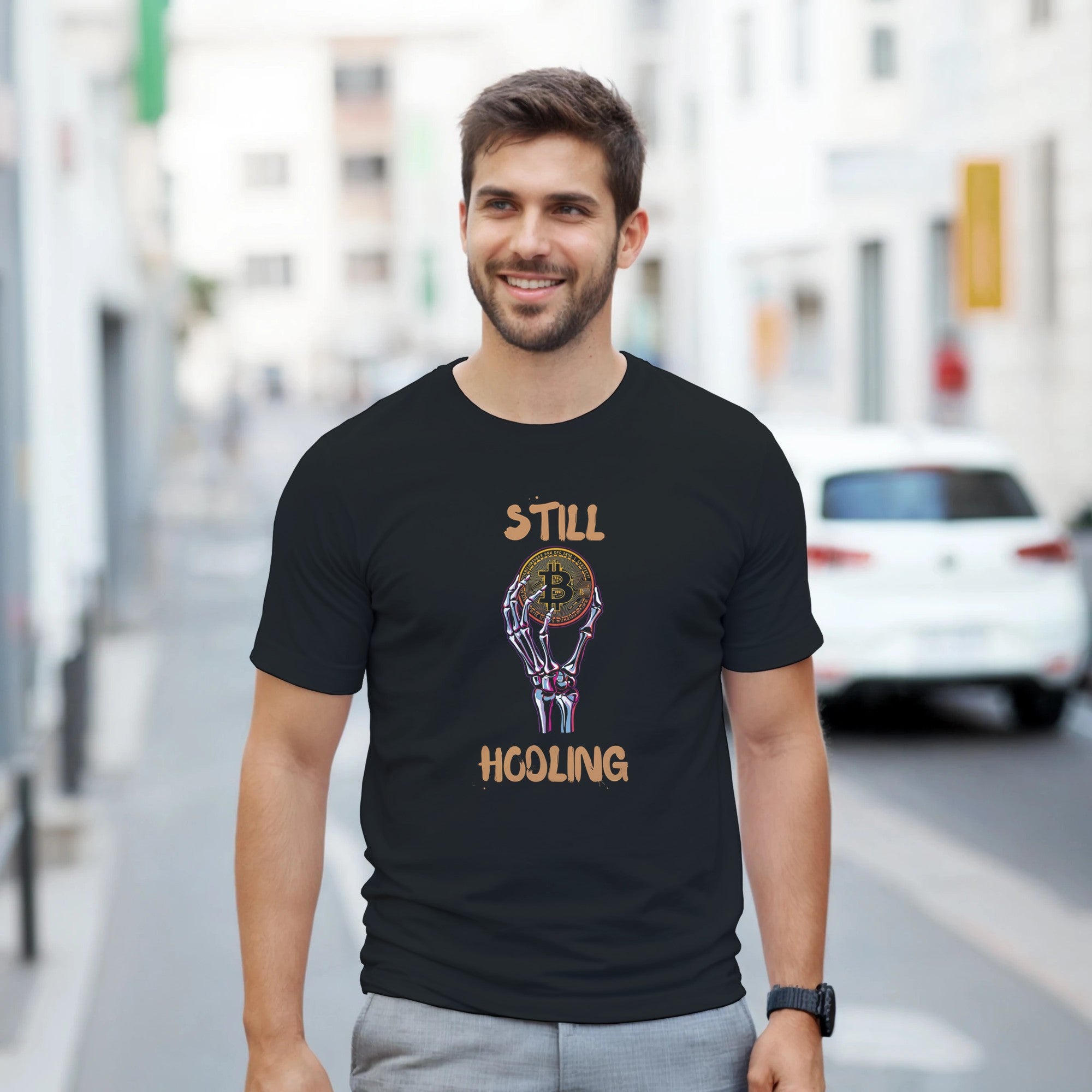Man wearing a black t-shirt with a Bitcoin design and text on a city street.
