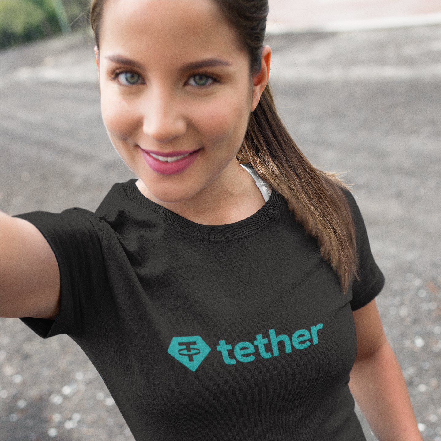 Woman wearing a black t-shirt with Tether logo outdoors